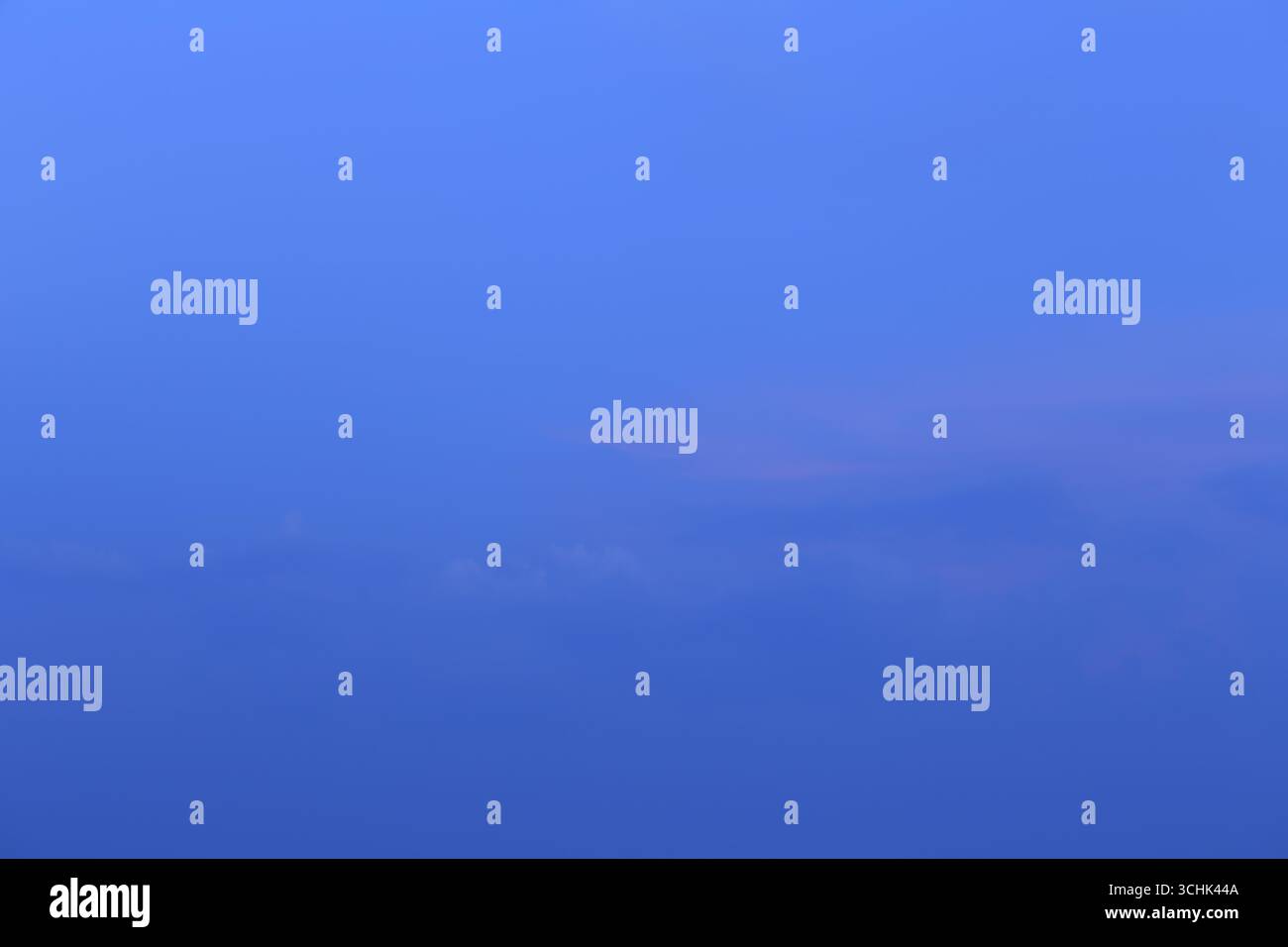 Questa immagine cattura un cielo blu sereno con dolci nuvole al crepuscolo, creando un'atmosfera tranquilla e tranquilla perfetta per evocare un senso di calma. Foto Stock