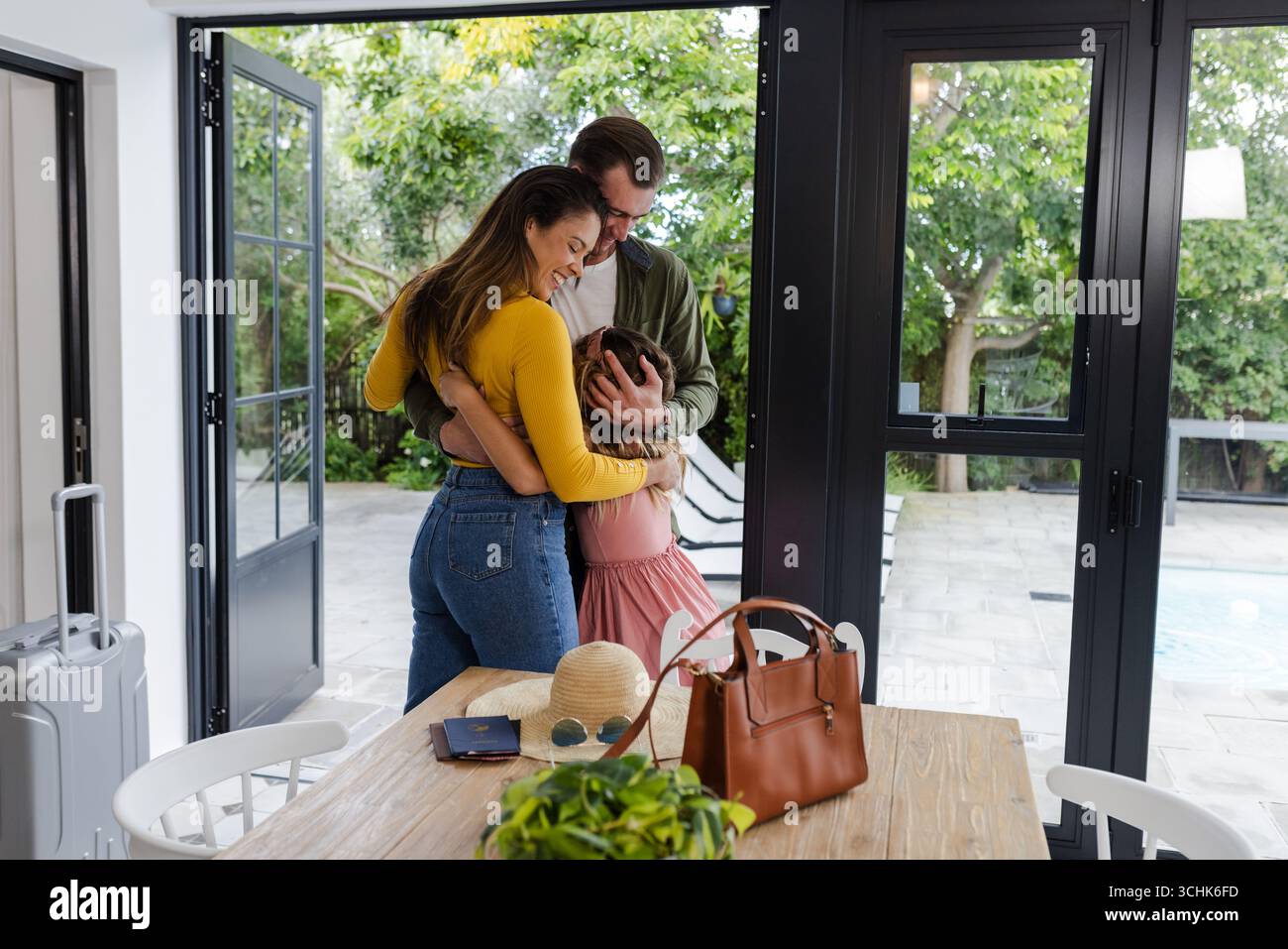 La famiglia abbraccia calorosamente il patio a bordo piscina, godendosi momenti di qualità insieme a casa Foto Stock