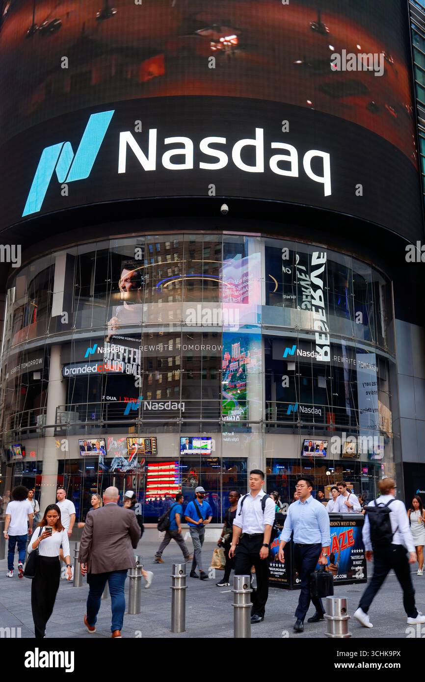 Persone e impiegati passano davanti a un evento Nasdaq MarketSite e al cartellone di Times Square al 4 Times Square (151 W 42nd St) di New York City. Foto Stock