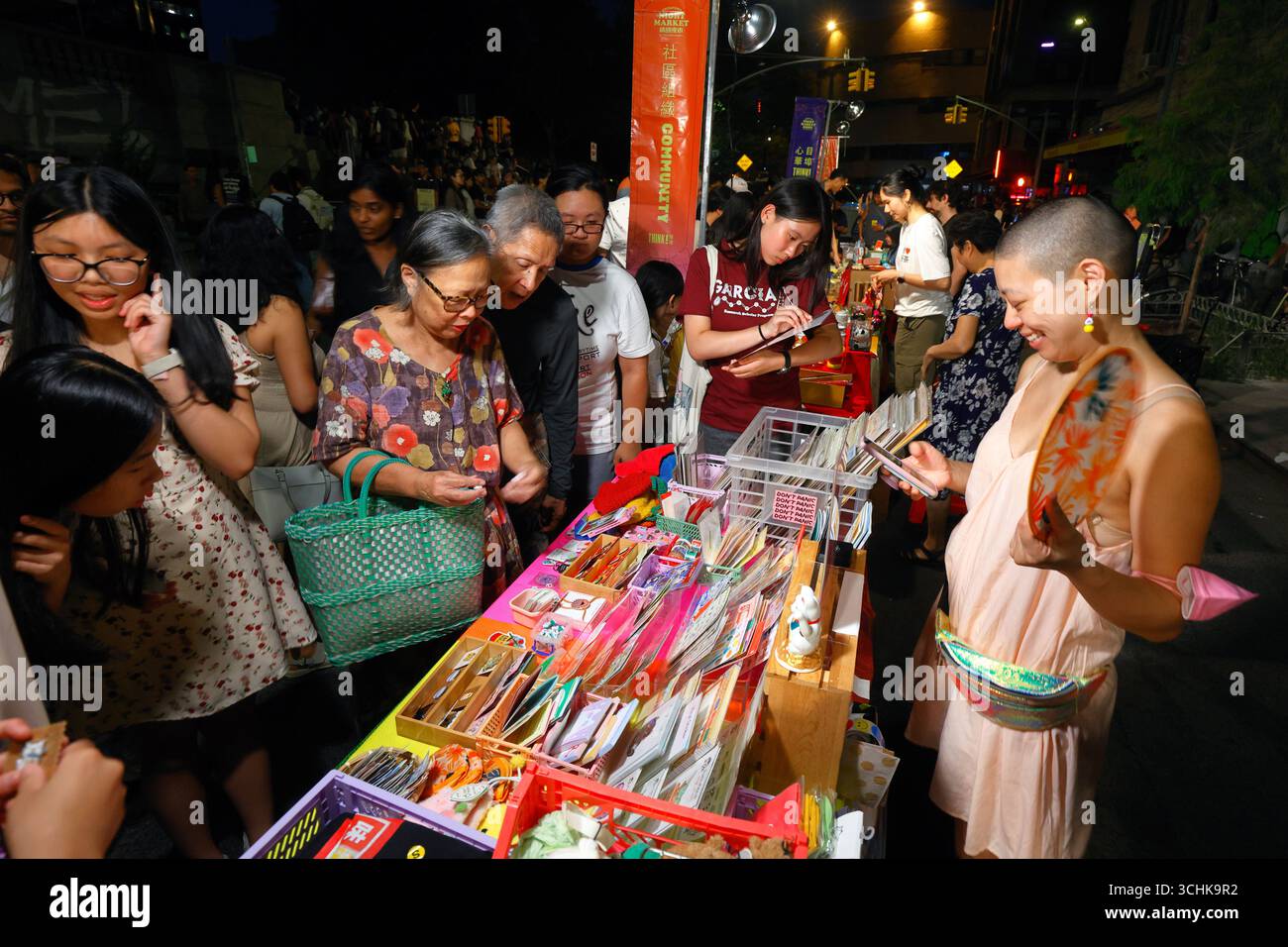 Persone che navigano in un tavolo del venditore al mercato notturno di Chinatown a Manhattan Chinatown, New York City, 15 agosto 2025 紐約 美國 Foto Stock