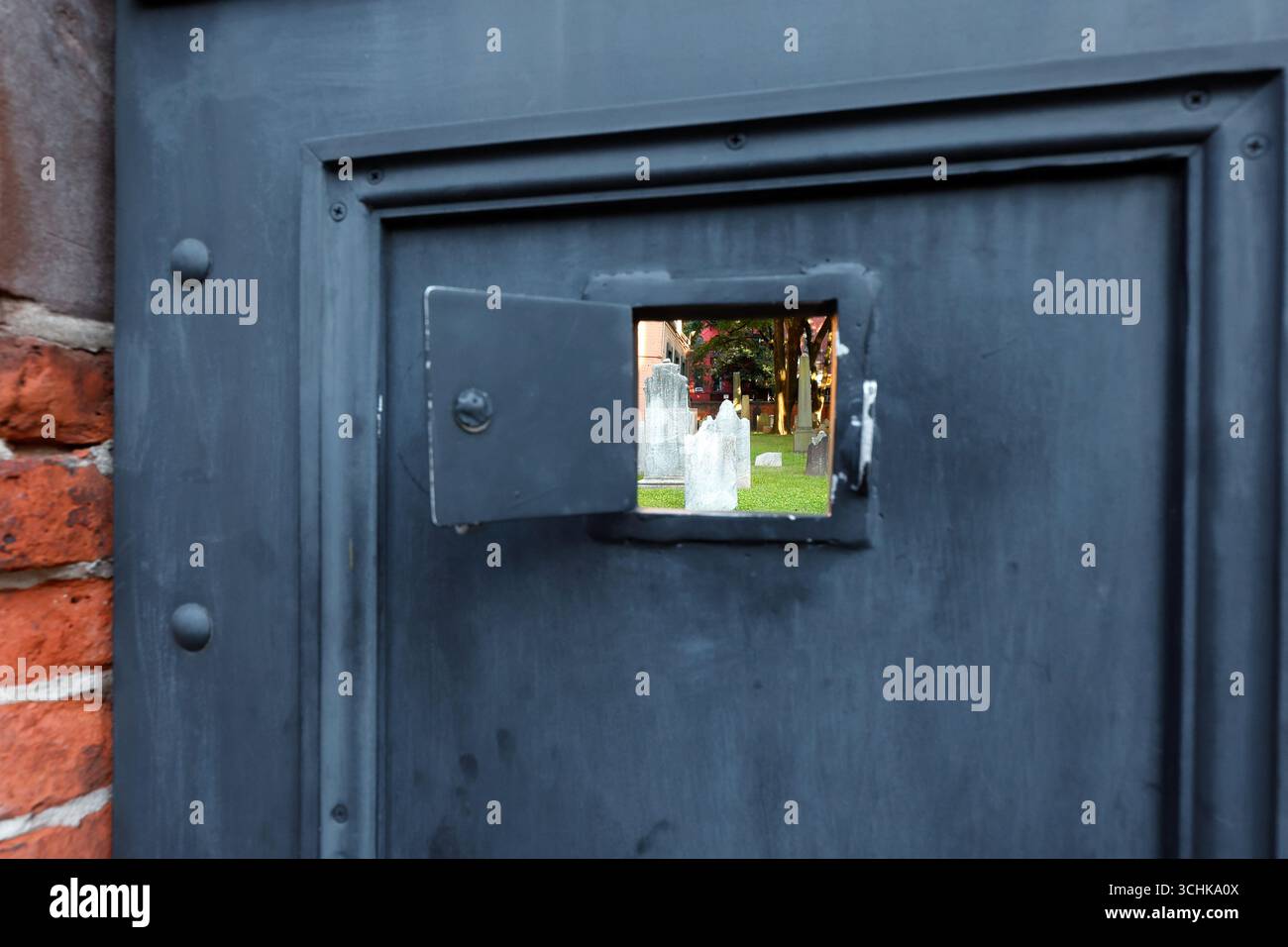 Guardando attraverso una mini porta all'interno di una porta del cimitero della Vecchia Cattedrale di San Patrizio, New York City Foto Stock