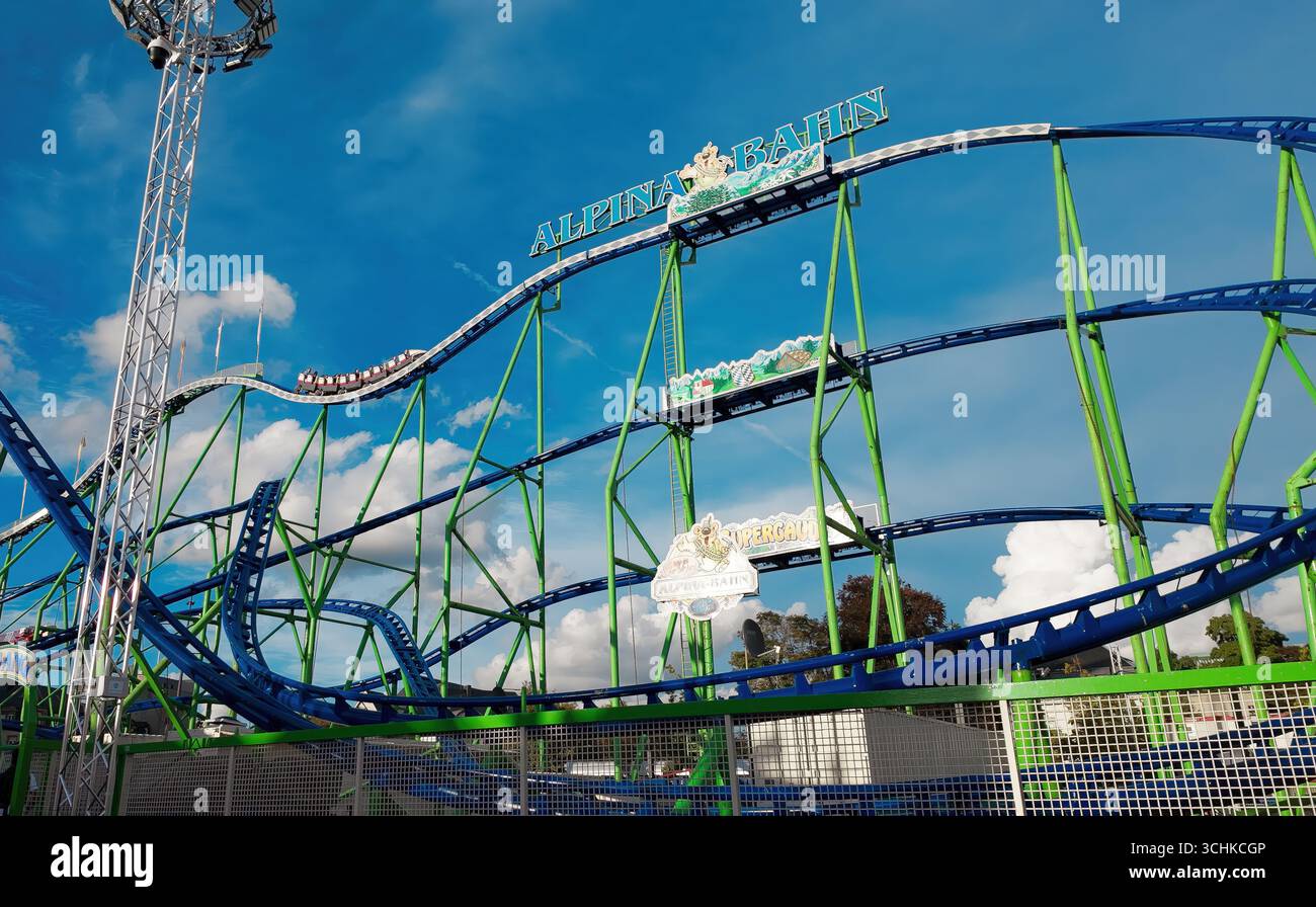 LUSSEMBURGO, EUROPA - 1 SETTEMBRE 2025 - Rollercoaster Cars che salgono in cima al parco divertimenti Schueberfouer di Luxemburg City, contro un cielo blu con Foto Stock