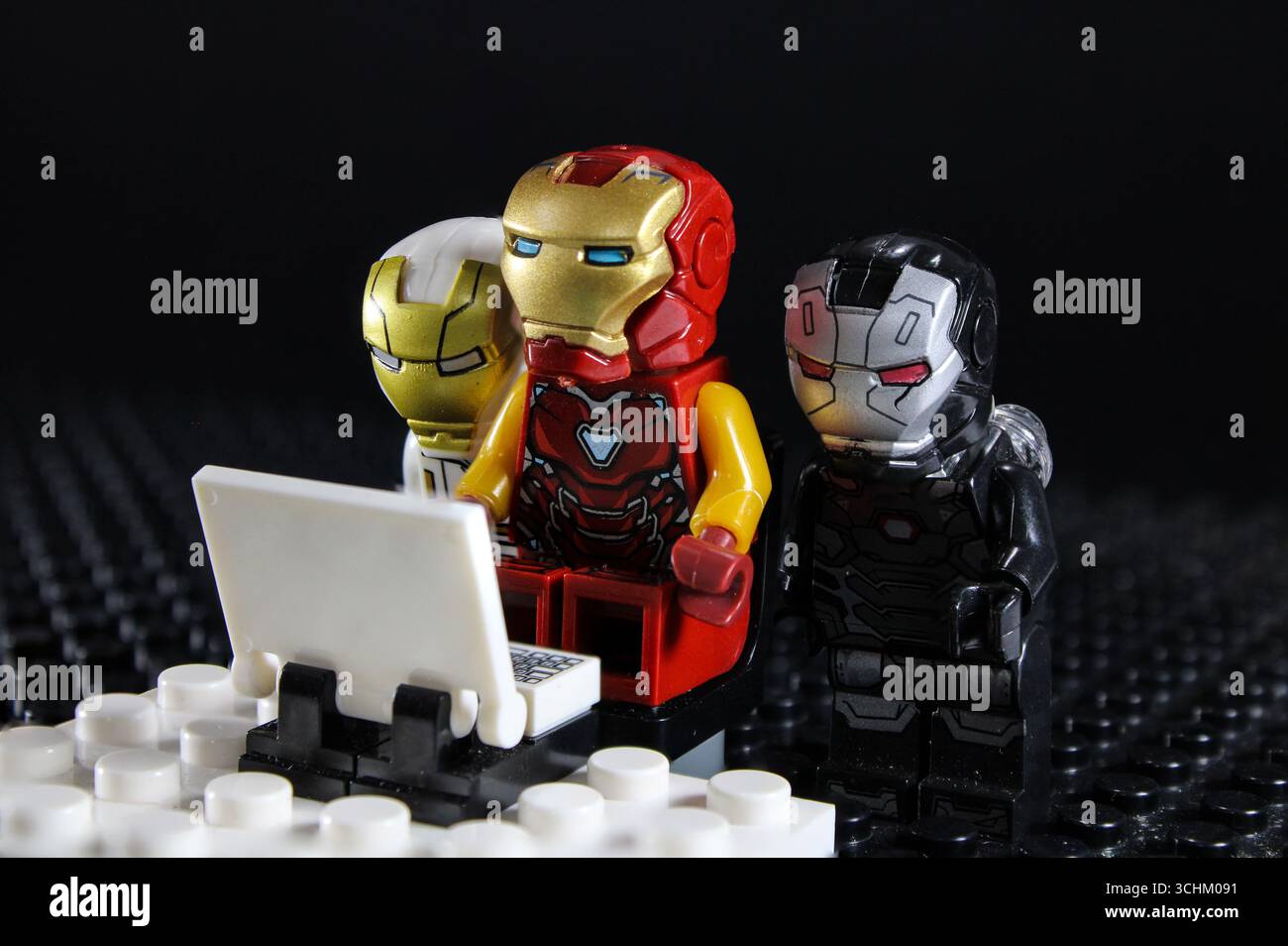LEGO Ironman e i suoi amici fissano il suo portatile mentre fa le sue ricerche Foto Stock