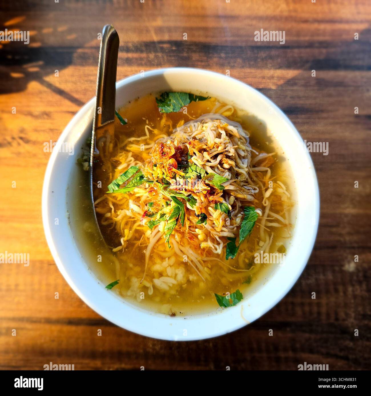 Zuppa di spaghetti indonesiani con pollo, erbe e verdure in brodo salato, autentico cibo di strada asiatico servito caldo nella ciotola - Immagine stock catturata con smartphone