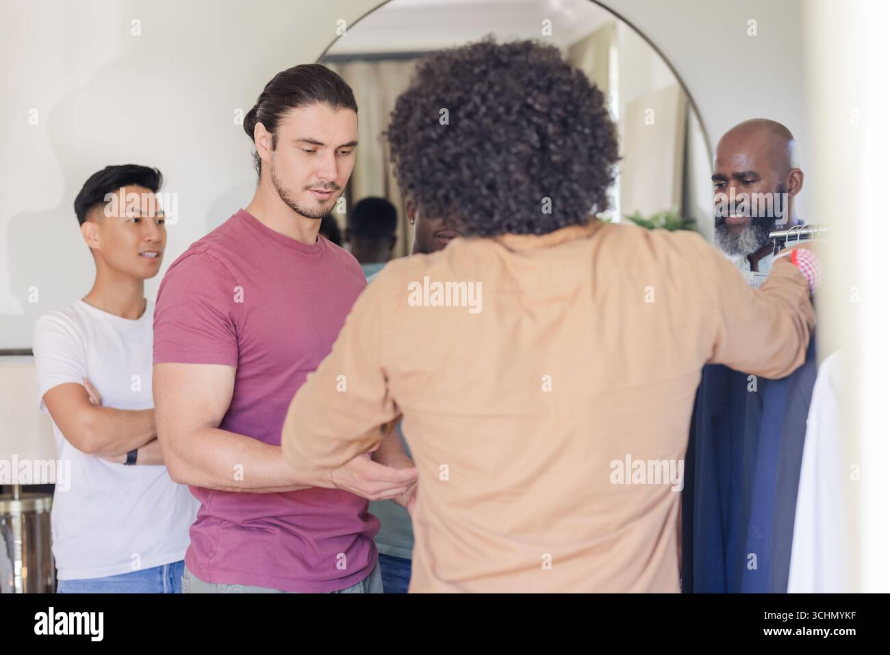 Sposo e amici selezionano abiti e si preparano alla celebrazione del giorno del matrimonio Foto Stock