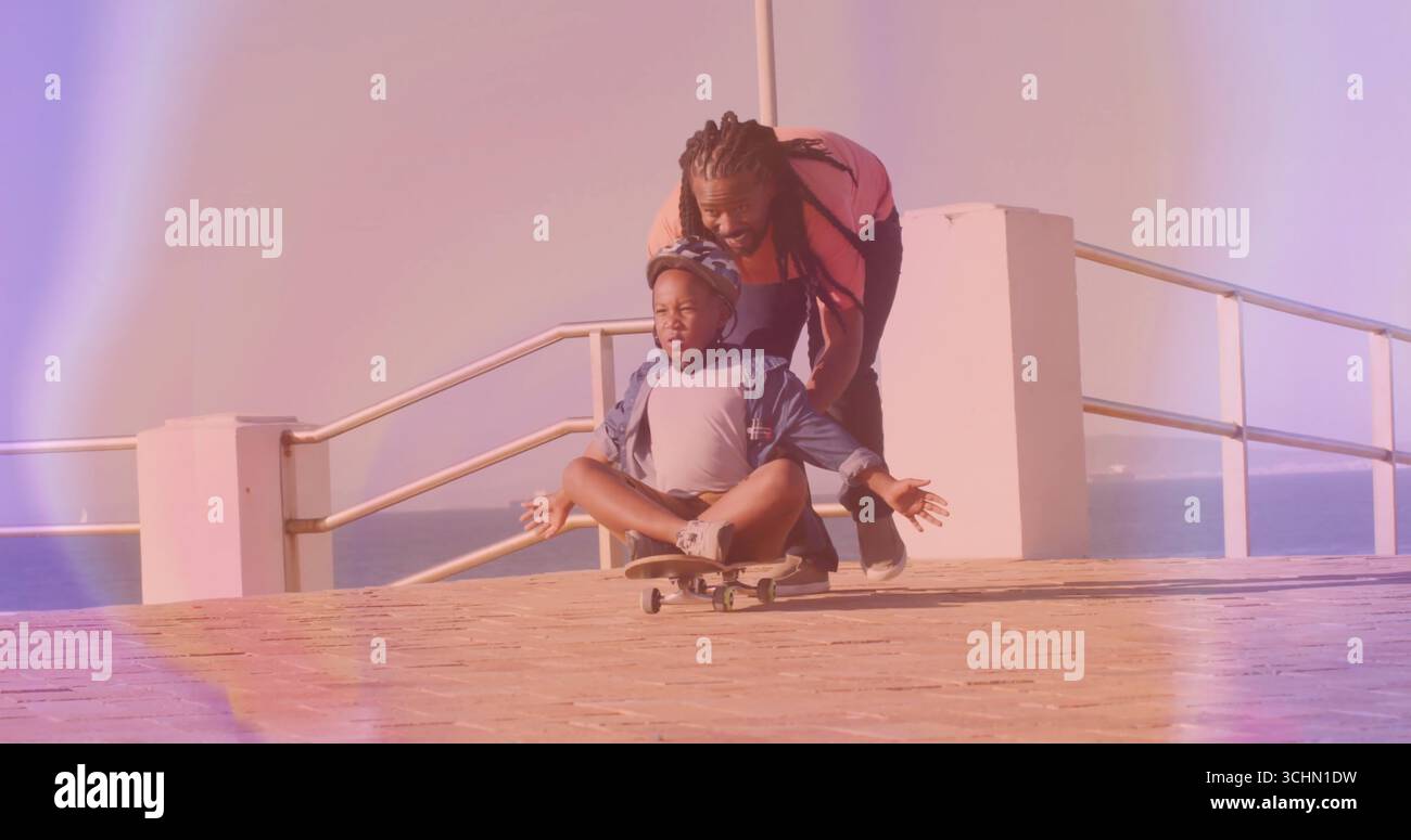 Spingendo il padre guidando il ragazzo che bilancia lo skateboard sulla passerella, con casco di sicurezza e ringhiera in metallo Foto Stock