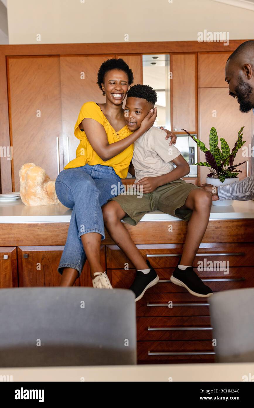 Famiglia sorridente che si diverte a trascorrere momenti di qualità insieme nella cucina moderna di casa Foto Stock