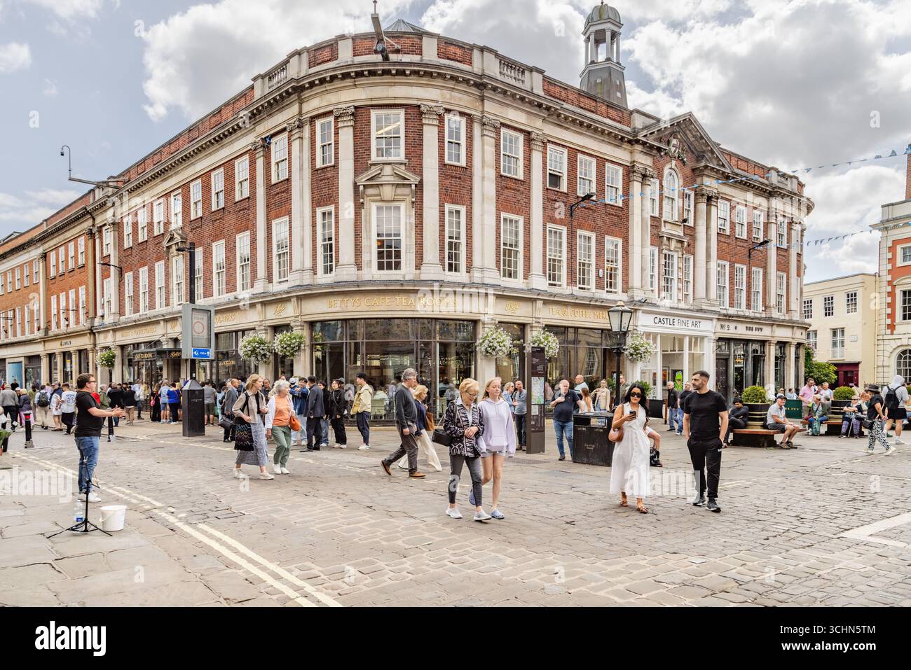 Turisti e gente del posto fuori dalle sale da tè del Bettys Cafe a York, Inghilterra, un famoso punto di riferimento del patrimonio britannico conosciuto per il tè pomeridiano e il fascino storico. Foto Stock