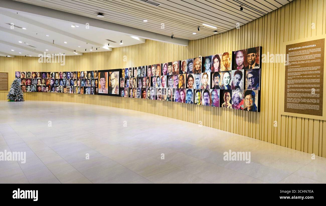 Sala espositiva con ritratti di personaggi storici esposti su lunghe pareti della galleria. Giacarta, Indonesia - 17 dicembre 2023 - Immagine stock catturata con smartphone