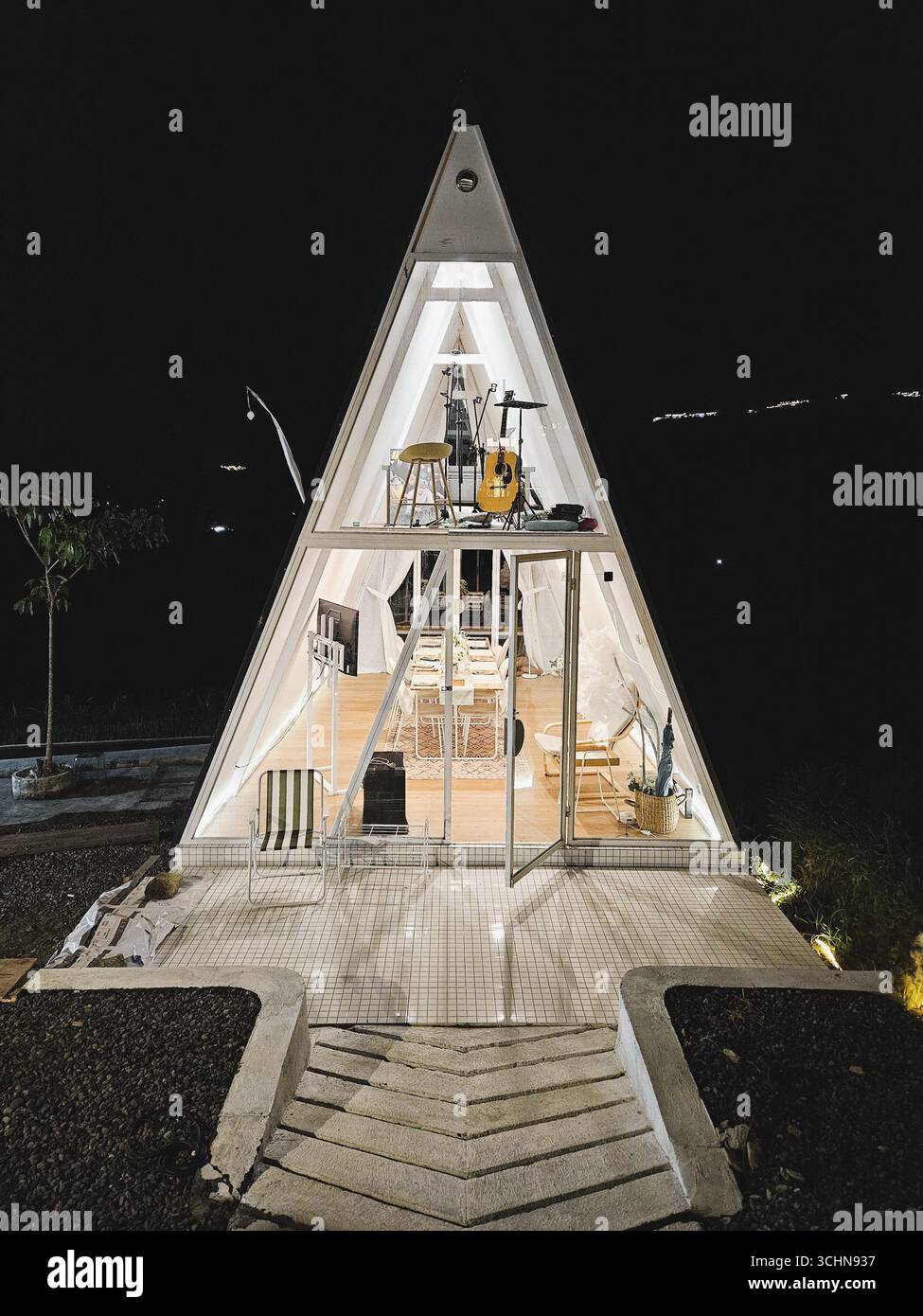 Moderno edificio triangolare illuminato di notte con un'architettura unica e un design luminoso. Yogyakarta, Indonesia - 17 febbraio 2024 - Immagine stock catturata con smartphone