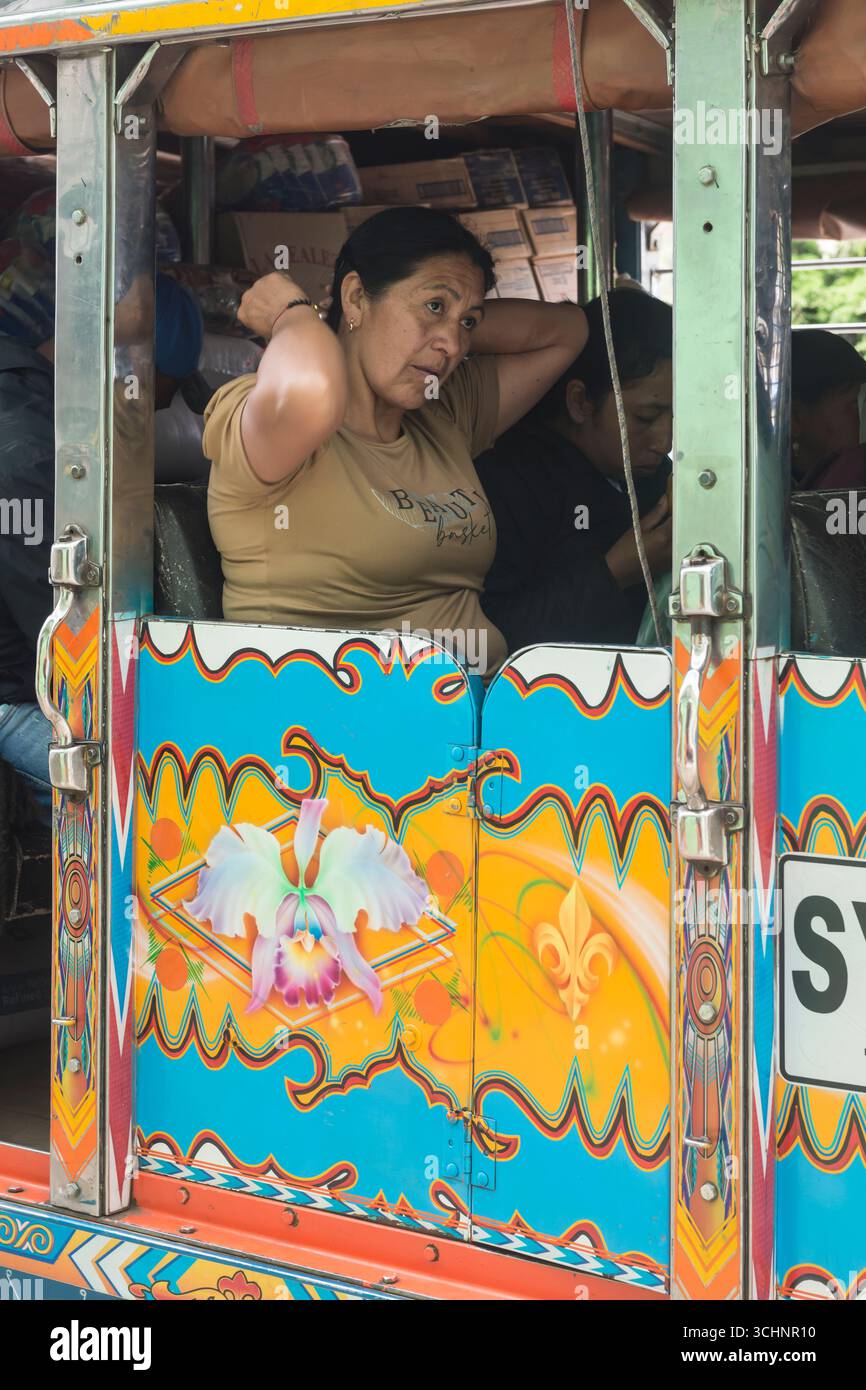 Donna pasquale in un autobus Chiva nella città di Silvia, Dipartimento di Cauca, Colombia Foto Stock