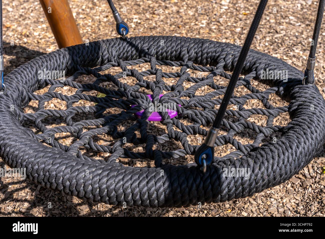 Sedile girevole con nido di funi, struttura circolare nera nel parco giochi all'aperto Foto Stock