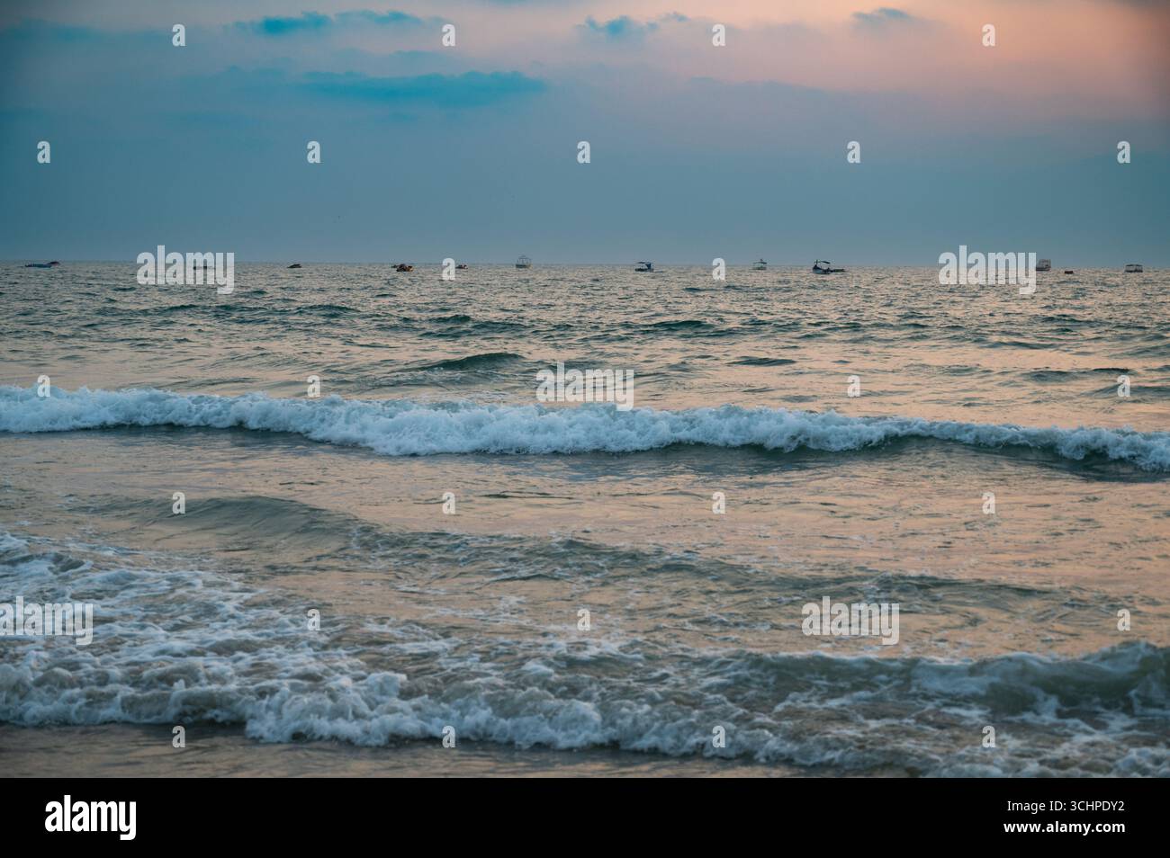 Tramonto sulla spiaggia di Colva Goa nell'India meridionale, silhouette di barche, costa occidentale tropicale, Mar Arabico in Asia, destinazione turistica Foto Stock