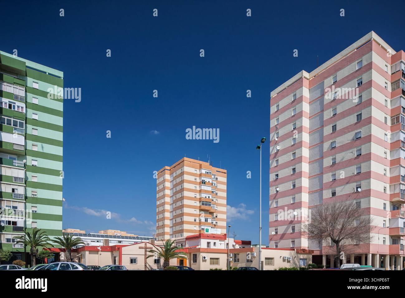 Edifici di media altezza con facciate a righe si affacciano sul litorale vicino a Poniente Beach, mescolando la vita urbana con le vedute costiere della Spagna. Foto Stock