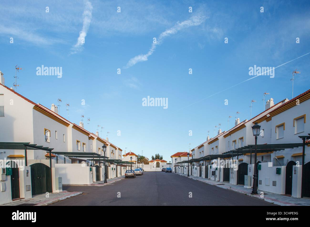 Le case dipinte di bianco con tetti di tegole rosse creano un'atmosfera serena nella zona suburbana di Aljarafe, valorizzando le strade tranquille. Foto Stock