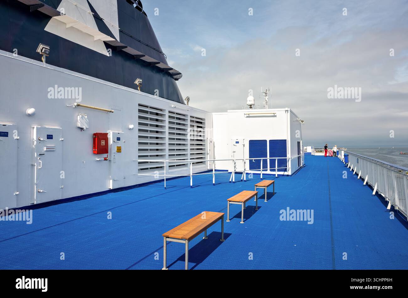 DFDS Ferry Deck Christianshavn Denmark Oresund // CHRISTIANSHAVN, Danimarca - il ponte di un traghetto DFDS è visibile, con una superficie blu brillante e panchine in legno. L'esterno del traghetto include sezioni bianche e blu scuro, con prominenti griglie di ventilazione. In lontananza, lo stretto di Öresund separa Danimarca e Svezia, con altre navi in acqua. Il servizio di traghetto collega la Danimarca con altri paesi scandinavi e baltici, offrendo viaggi marittimi panoramici. DFDS, precedentemente nota come United Steamship Company, è una compagnia di navigazione danese che opera rotte attraverso il Nord Europa Foto Stock DFDS Ferry Deck Christianshavn Denmark Oresund // CHRISTIANSHAVN, Danimarca - il ponte di un traghetto DFDS è visibile, con una superficie blu brillante e panchine in legno. L'esterno del traghetto include sezioni bianche e blu scuro, con prominenti griglie di ventilazione. In lontananza, lo stretto di Öresund separa Danimarca e Svezia, con altre navi in acqua. Il servizio di traghetto collega la Danimarca con altri paesi scandinavi e baltici, offrendo viaggi marittimi panoramici. DFDS, precedentemente nota come United Steamship Company, è una compagnia di navigazione danese che opera rotte attraverso il Nord Europa Foto Stock