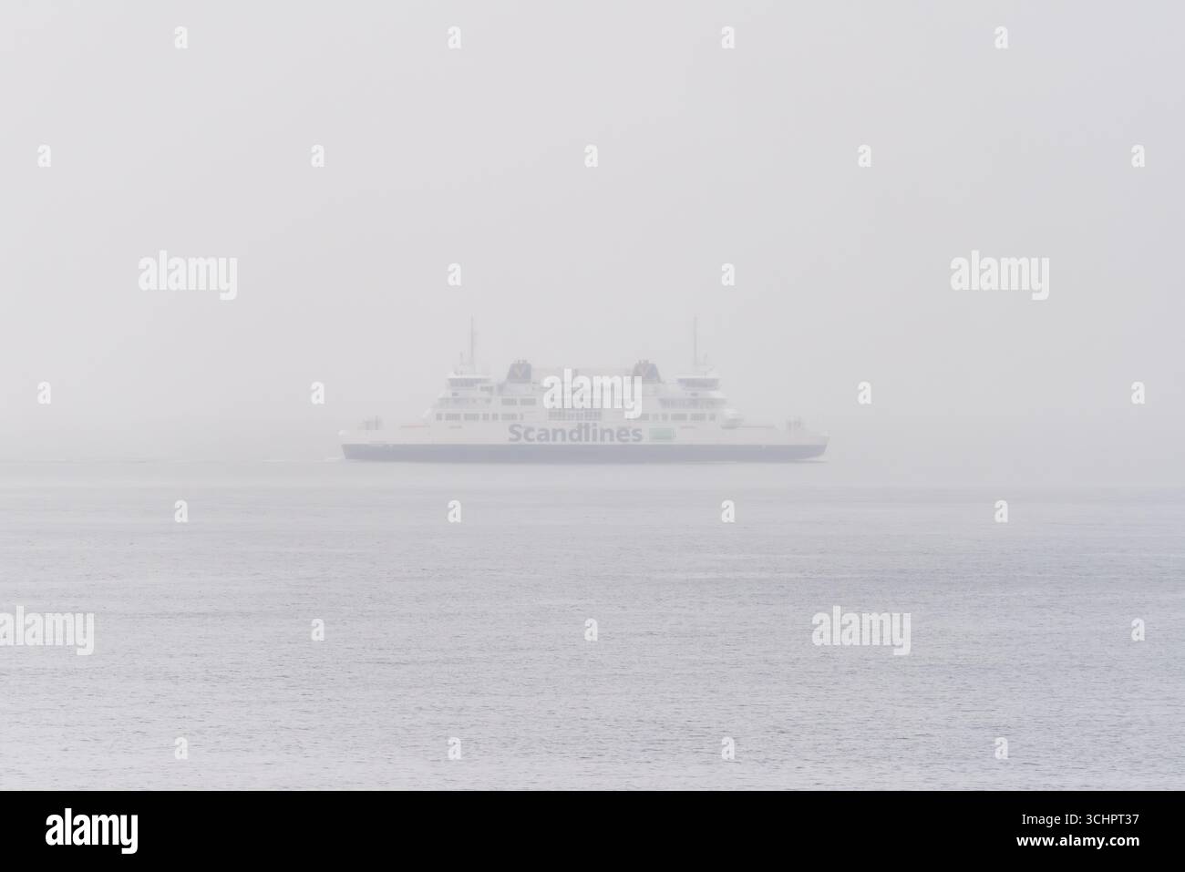Scandlines Ferry a Fog sullo stretto di Oresund vicino a Helsingborg Svezia // HELSINGBORG, Svezia — Un traghetto Scandlines naviga attraverso una fitta nebbia sullo stretto di Oresund vicino a Helsingborg, Svezia. Lo stretto di Oresund, noto anche come Sound, è uno stretto che forma parte del confine tra Danimarca e Svezia. Si tratta di un canale di navigazione molto trafficato che collega il Mar Baltico allo stretto del Kattegat, che conduce al Mare del Nord. Scandlines è una compagnia di traghetti tedesca che opera rotte attraverso il Mar Baltico. Foto Stock
