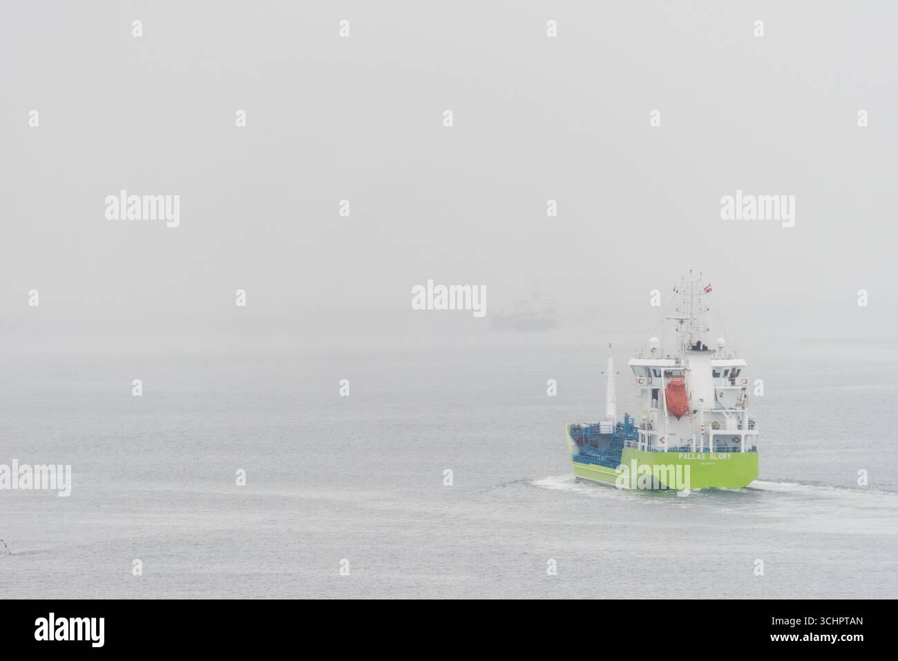 Nave Gloria Pallas nello stretto di Oresund vicino a Helsingborg Svezia // HELSINGBORG, Svezia — la Gloria Pallas, una nave da carico, naviga attraverso lo stretto di Oresund vicino a Helsingborg, Skåne, Svezia. Lo stretto collega il Mar Baltico allo stretto di Kattegat ed è una delle principali vie di navigazione. Un altro vaso è visibile a distanza attraverso la nebbia. La Gloria Pallas è registrata a la Valletta, Malta. Foto Stock