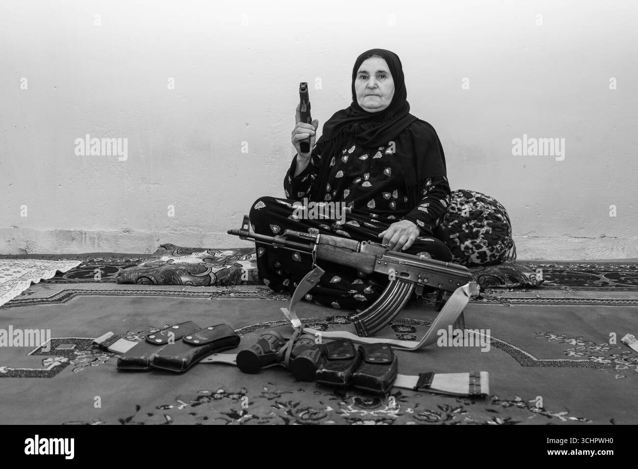 Le donne curde simboleggiano coraggio e resistenza, vitali nelle lotte politiche e civili. In Kurdistan, le case spesso tengono pistole, riflettendo la cultura, strug Foto Stock