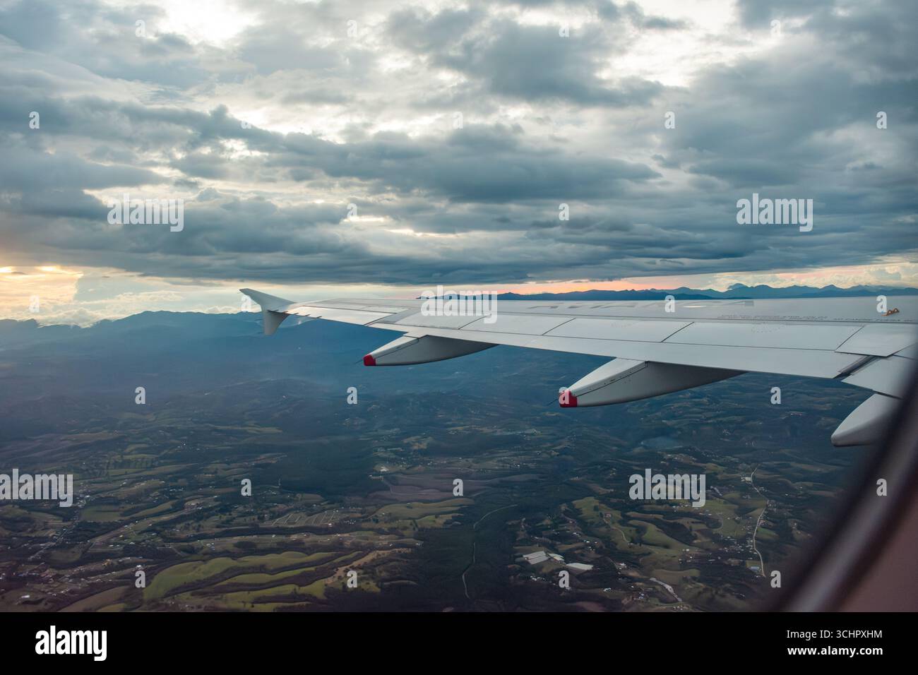 Splendida vista aerea da un'ala di aeroplano su lussureggianti paesaggi e spettacolari nuvole, catturando la bellezza della campagna colombiana. Foto Stock