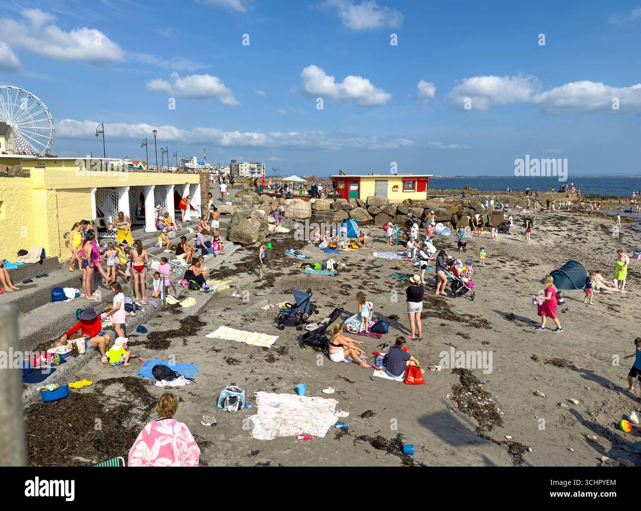 La spiaggia di Salthill, Galway, al largo del Prom, affollata di gente in una calda domenica di sole nell'agosto 2025 - Immagine stock catturata con smartphone