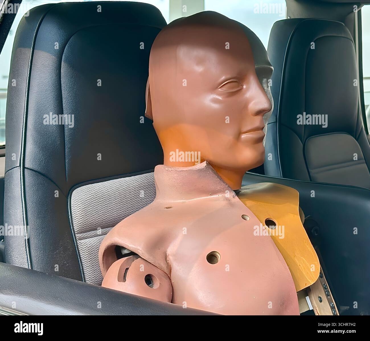 Manichino per crash test seduto sul sedile del passeggero di un veicolo moderno, utilizzato per test di sicurezza e ricerca di ingegneria automobilistica. Foto Stock