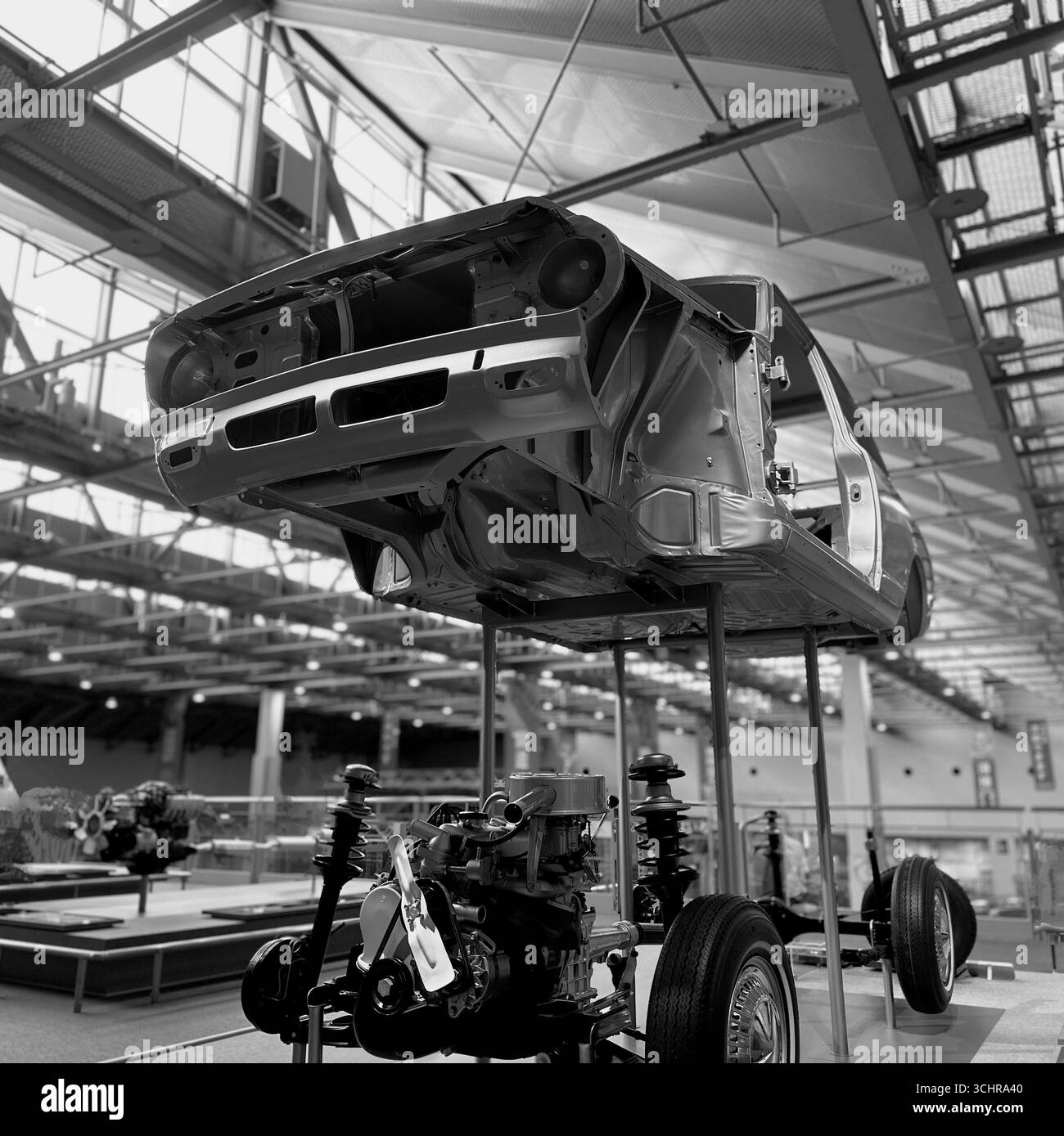 Immagine in bianco e nero della struttura e del telaio dello scheletro di un'auto, completa di motore e sospensioni, esposta in un museo. Foto Stock