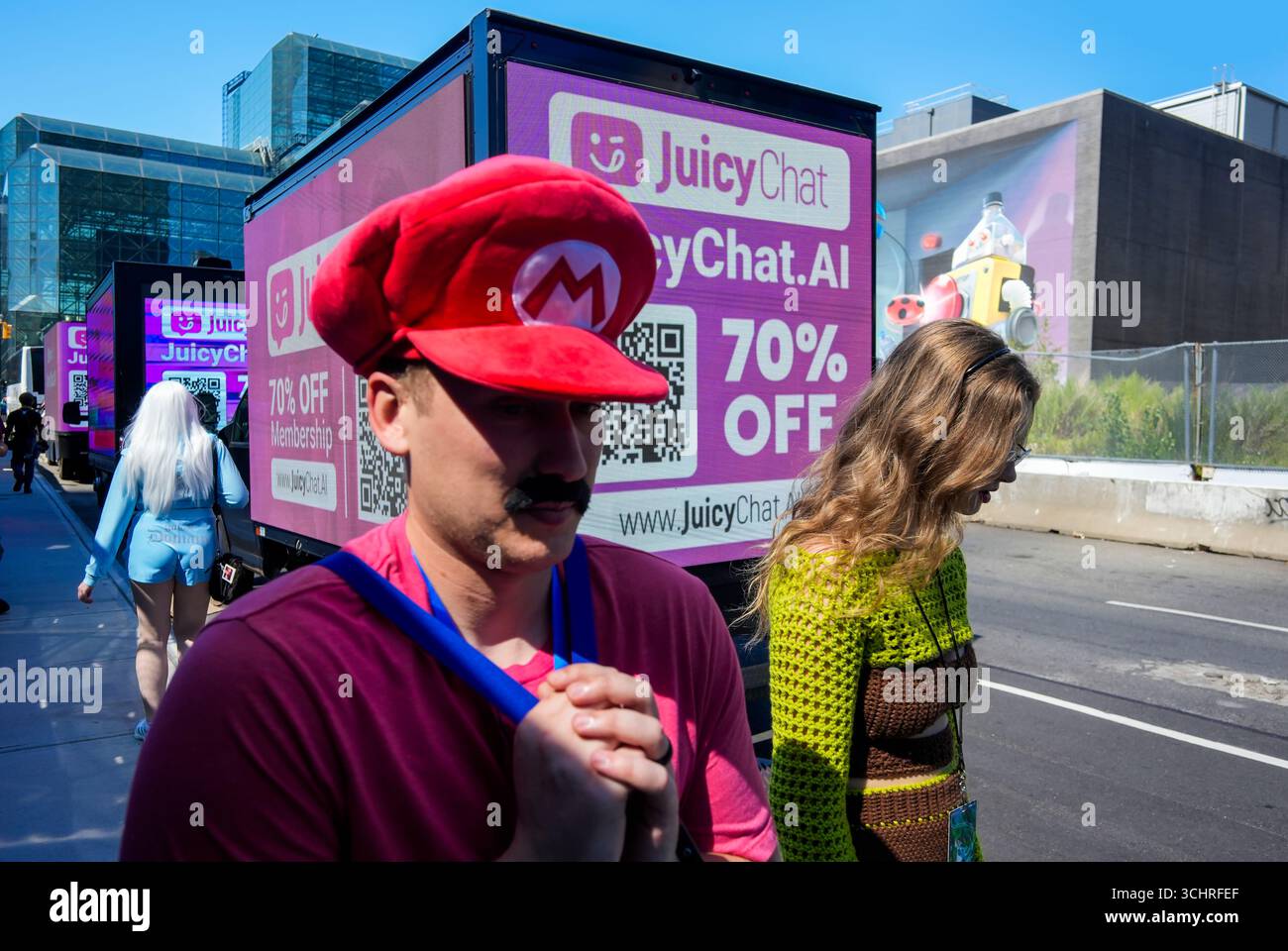 Gli appassionati di Cosplay al di fuori dello spettacolo di Anime NYC al Jacob Javits Convention Center di New York pass Truck che pubblicizzano JuicyChat.ai, creatore dei compagni chatbot di NSFW, visto venerdì 22 agosto 2025. (© Richard B. Levine) Foto Stock