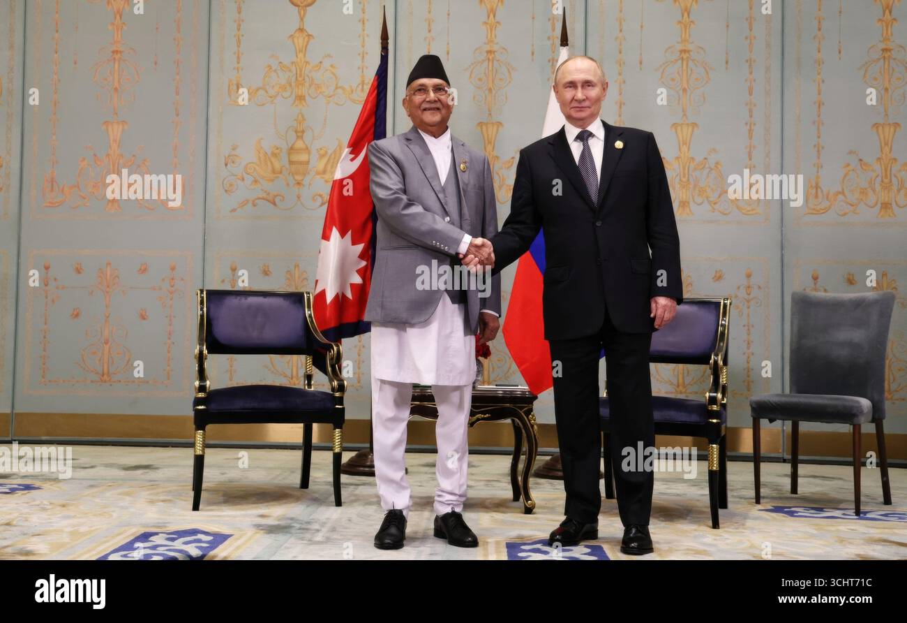 Tianjin, Cina. 1 settembre 2025. Il presidente russo Vladimir Putin, a destra, e il primo ministro nepalese Khadga Prasad Sharma oli, a sinistra, stringono la mano prima dell'inizio del loro incontro bilaterale a margine del vertice dell'Organizzazione di cooperazione di Shanghai al Meijiang Convention Center, il 1° settembre 2025, a Tianjin, in Cina. Credito: Alexander Kazakov/foto del governo russo/Alamy Live News Foto Stock