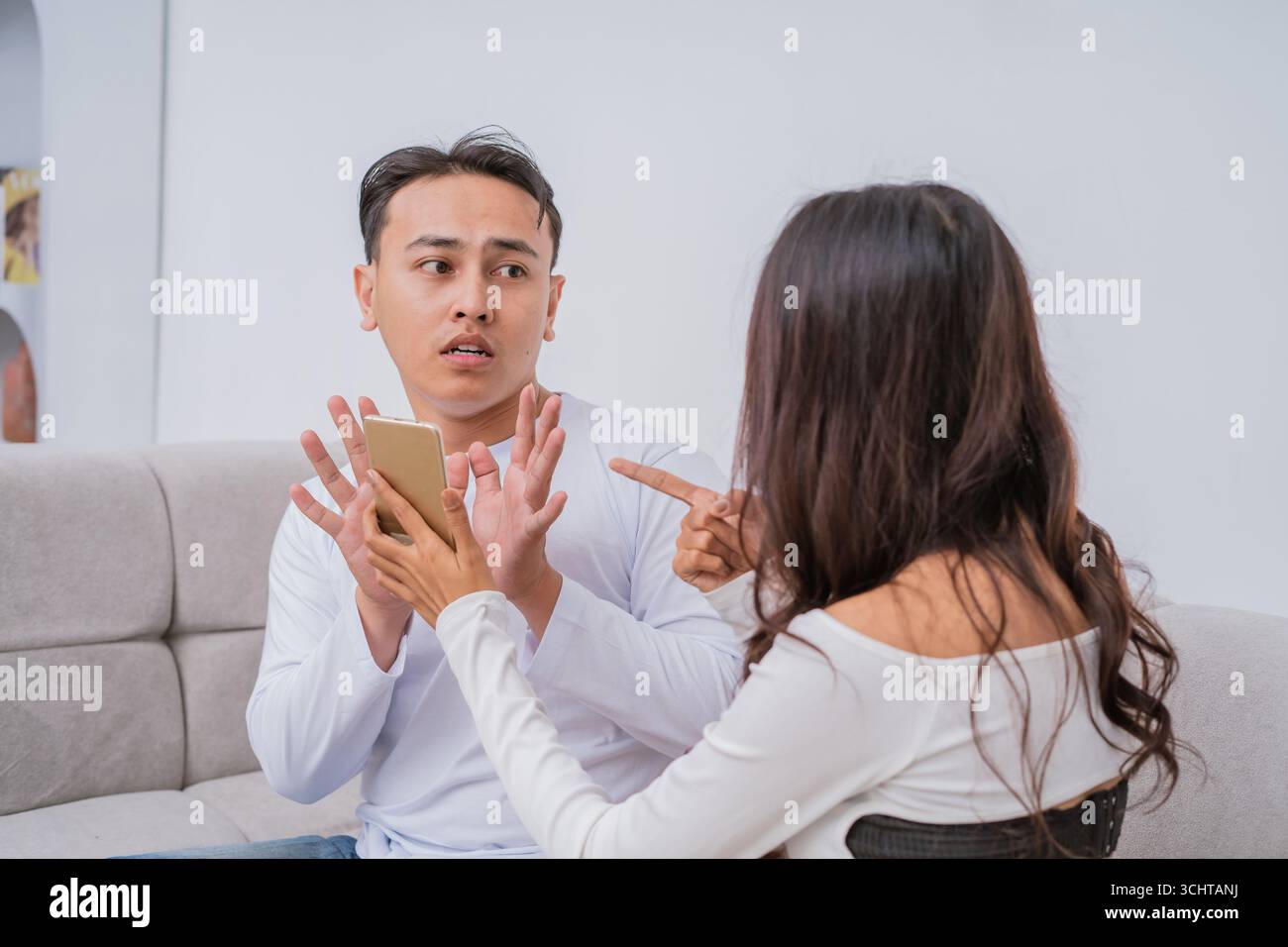 Conversazione tesa Una coppia non è d'accordo sull'interazione e l'utilizzo dello smartphone Foto Stock