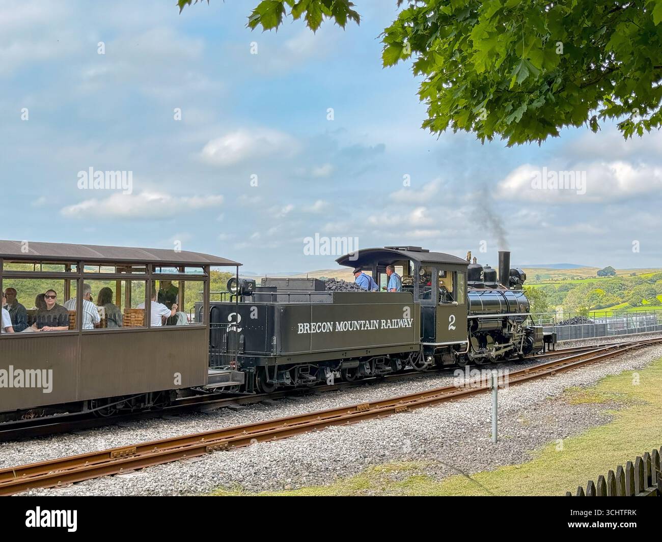 Merthyr Tydfil, galles, Regno Unito - 19 agosto 2025: Treno a vapore vintage a scartamento ridotto con passeggeri in partenza dalla stazione di Pant sulla Brecon Mountain Railway Foto Stock