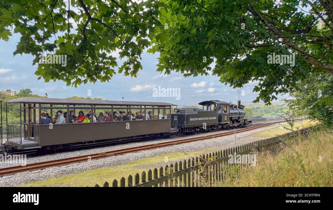 Merthyr Tydfil, galles, Regno Unito - 19 agosto 2025: Treno a vapore vintage a scartamento ridotto con passeggeri in partenza dalla stazione di Pant sulla Brecon Mountain Railway - Immagine stock catturata con smartphone