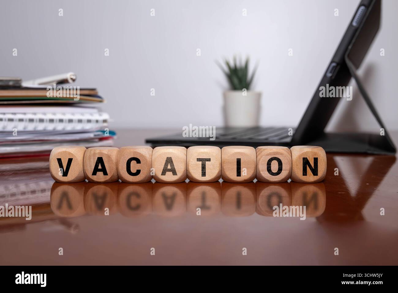 Sveglia con blocchi di legno che scrivono "VACANZA" isolata su sfondo nero, simboleggia la gestione del tempo, l'economia e il business. Blocchetti in legno monouso Foto Stock