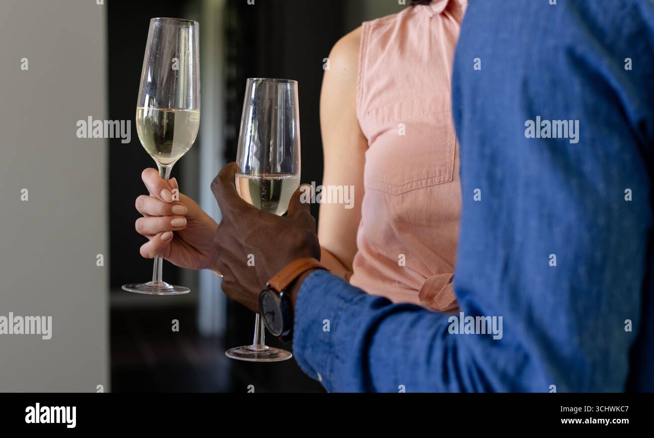 Diverse coppie brindate con bicchieri di champagne, per celebrare un'occasione speciale a casa Foto Stock