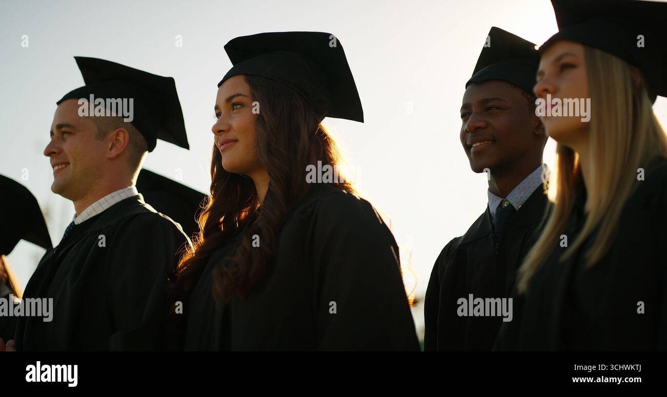 Laurea, studenti e gruppo con cappelli, cerimonia e celebrazione del traguardo o del successo accademico. Università, risultati e persone con vesti per Foto Stock