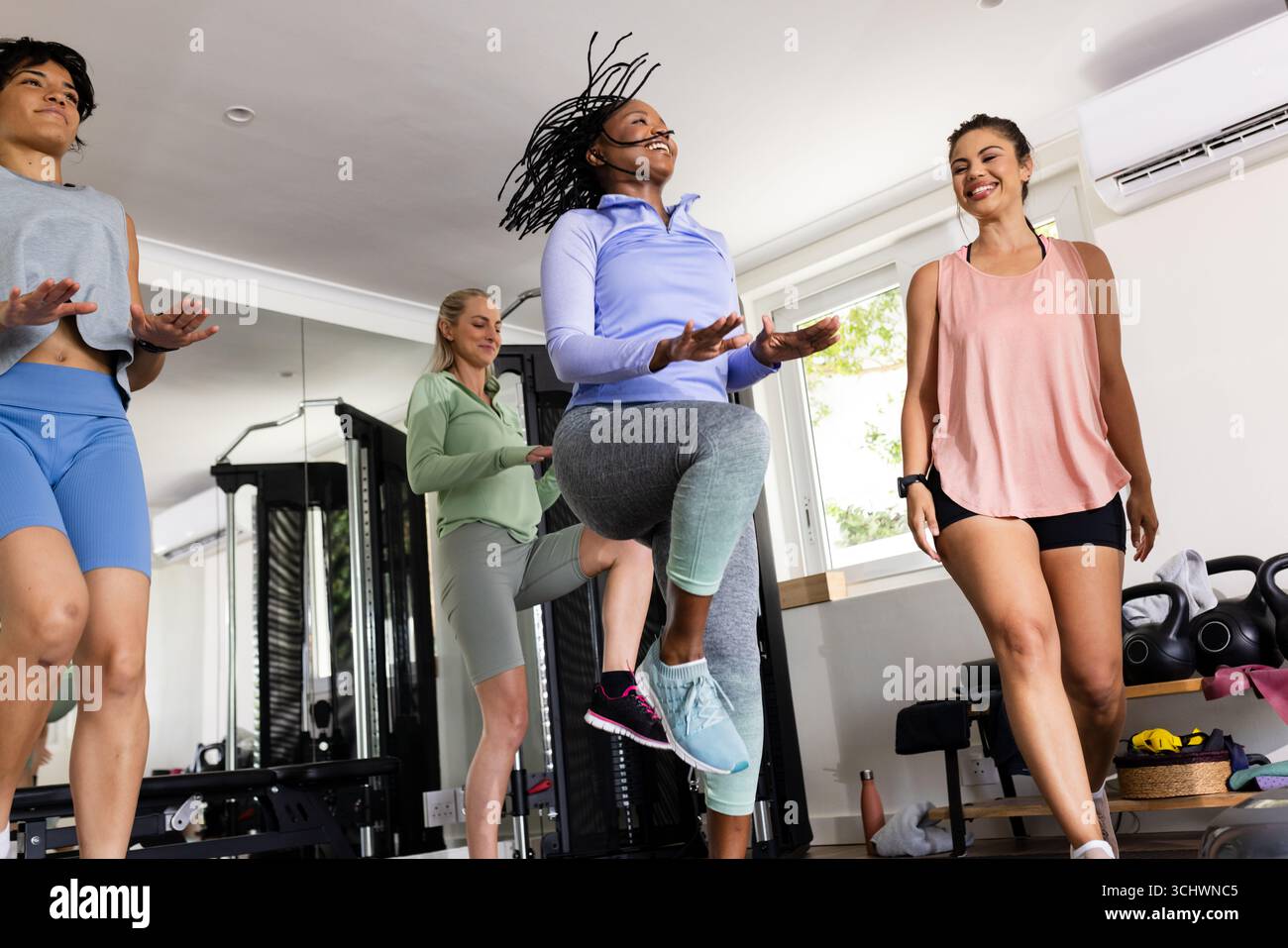 Donne che si allenano energicamente in palestra, godendosi una sessione di allenamento di gruppo Foto Stock