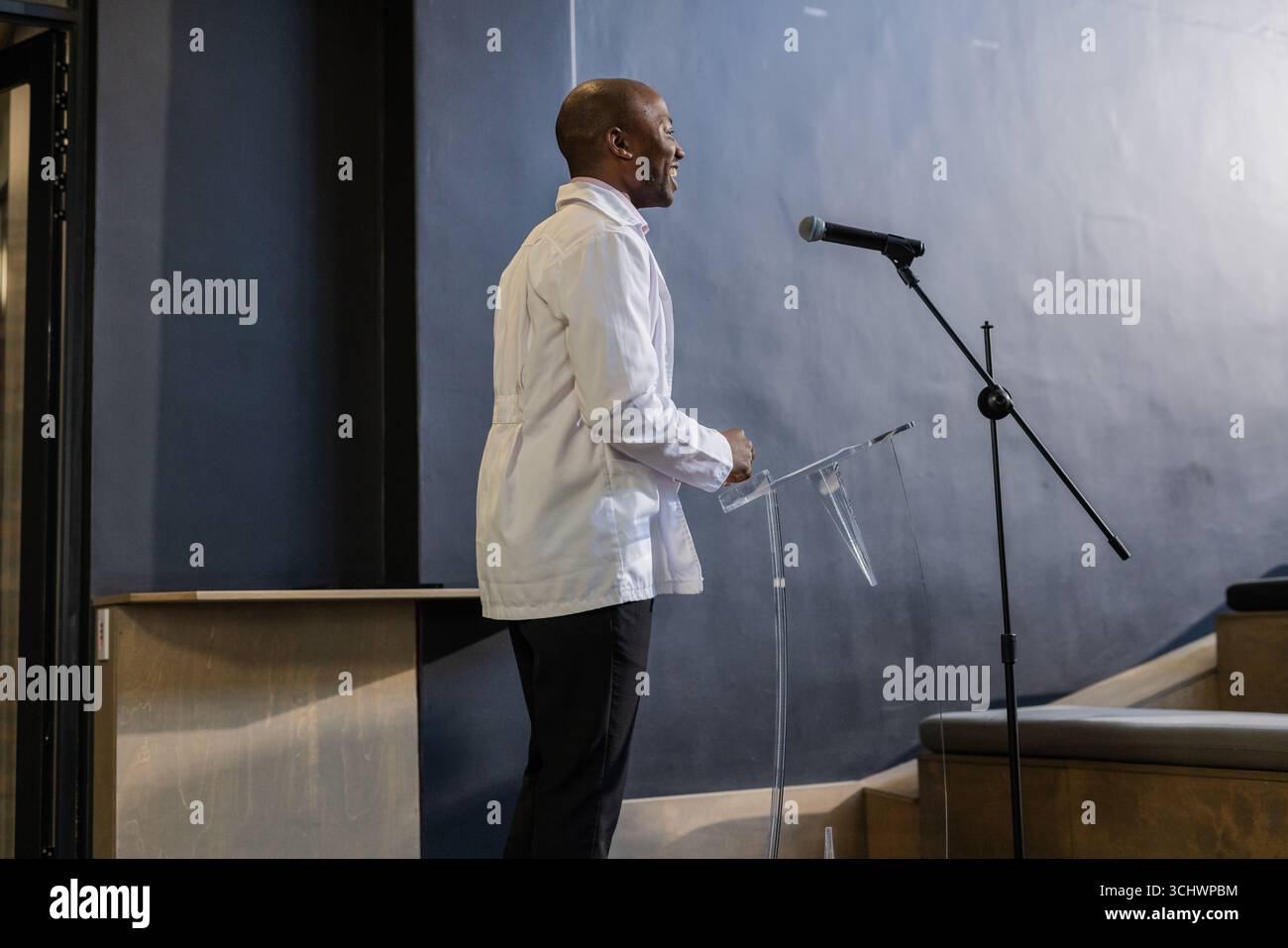 Parlando con fiducia sul podio, uomo d'affari che presenta a un evento professionale Foto Stock
