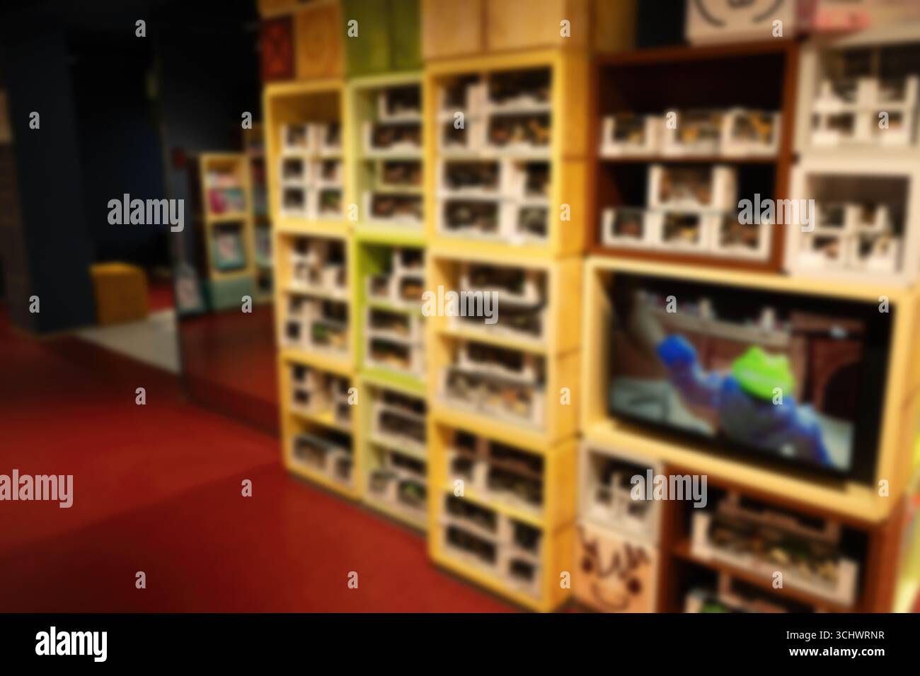 Una colorata sala giochi con schermi interattivi e scaffali per giocattoli e giochi in un ambiente adatto alle famiglie Foto Stock