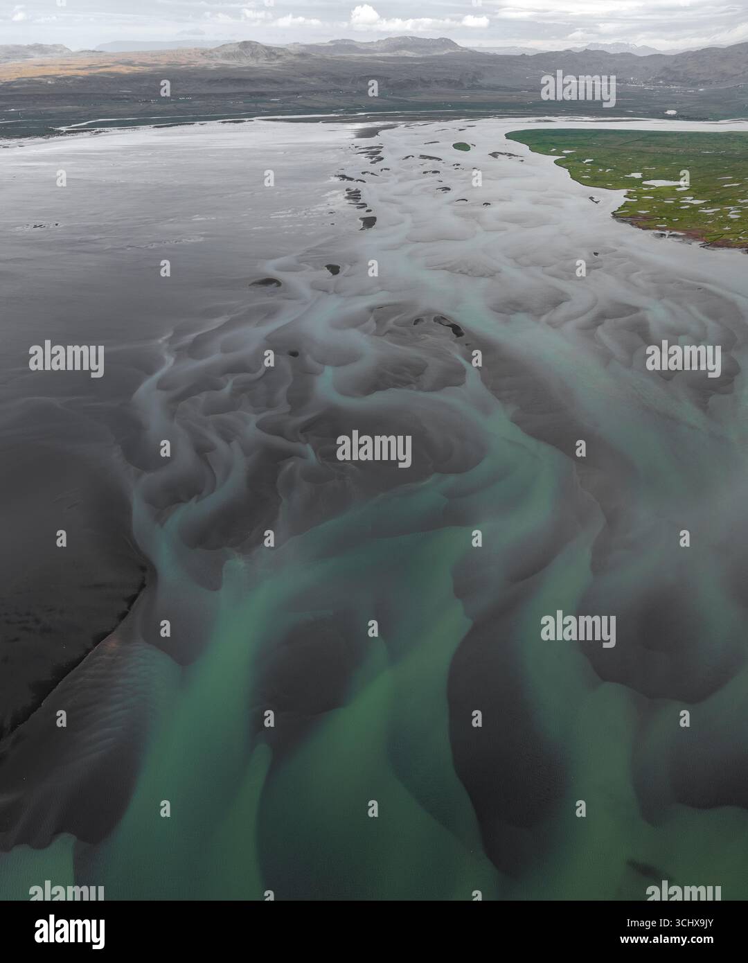 Vista aerea dei modelli glaciali dei fiumi che creano texture ipnotiche dove le sabbie scure incontrano le acque turchesi, Hvolsvllur, regione meridionale, Icela Foto Stock