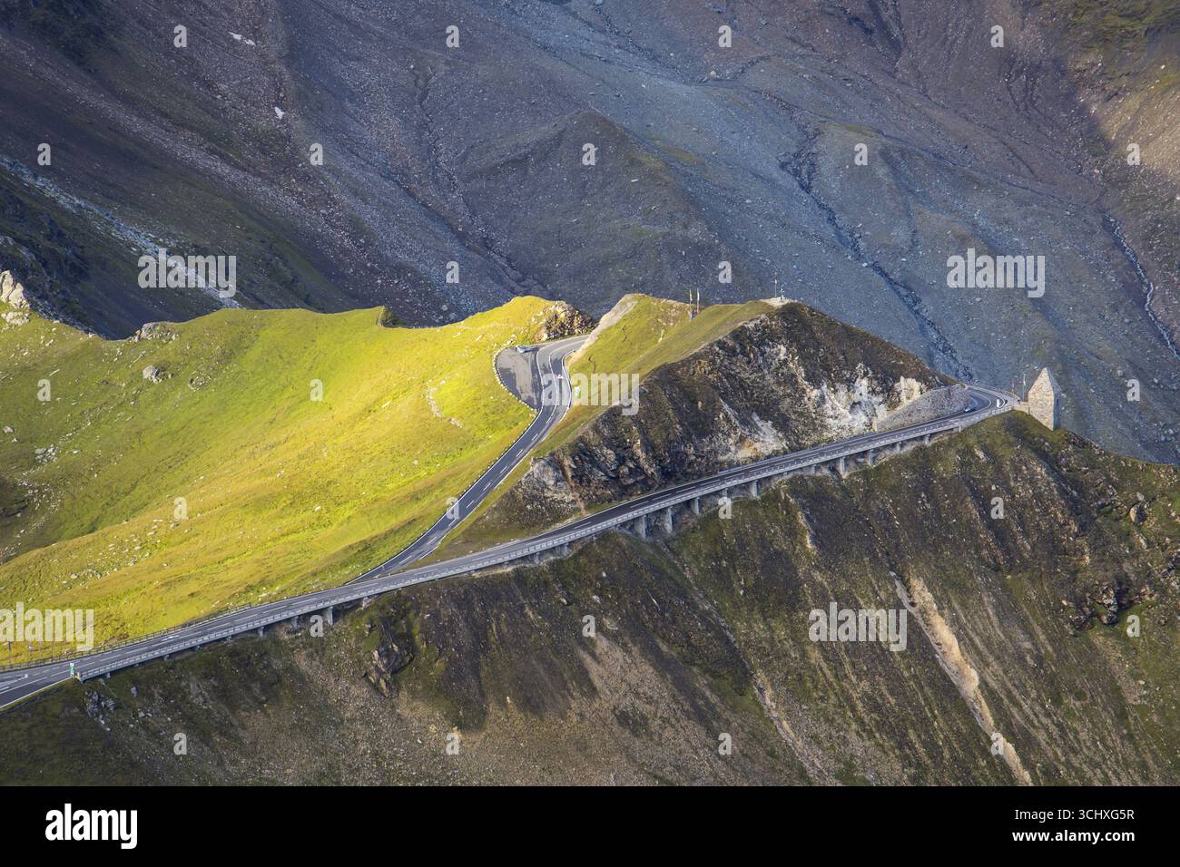 Vista aerea di una strada tortuosa che attraversa il paesaggio aspro e baciato dal sole della strada alpina Grossglockner, Fuscher Törl, Bruck an der Großglocknerstraße, Salisburgo, Austria. Foto Stock