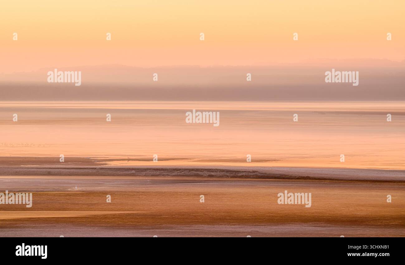 Lago Chew Valley all'alba nell'estate del 2025, molto arida, scattata con movimento intenzionale della fotocamera con Egret che si nutre nell'angolo in basso a sinistra Foto Stock