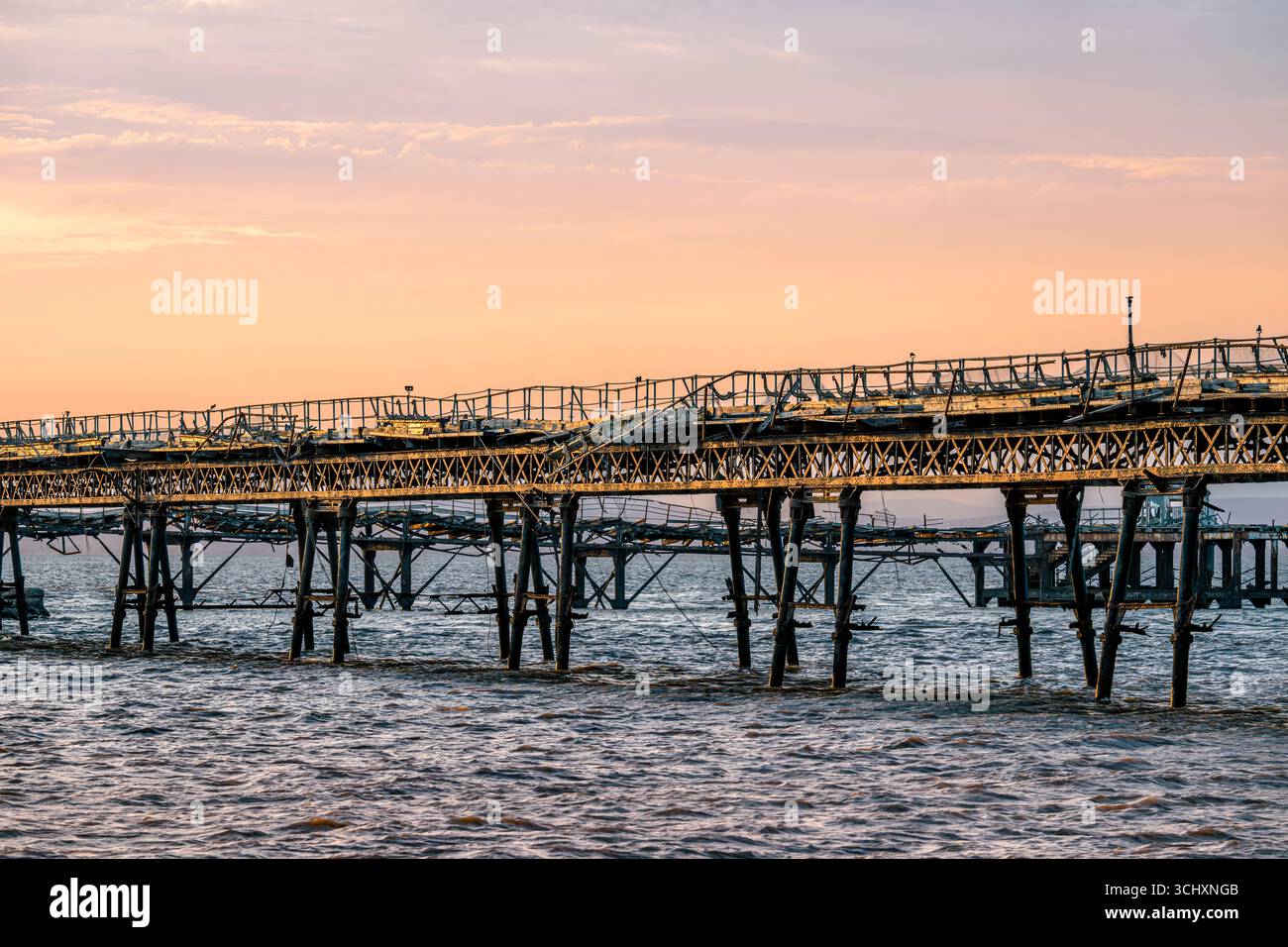 La passerella per il vecchio molo di Birnbeck al tramonto, che si trova nel canale di Bristol a Weston-super-Mare, North Somerset, Regno Unito Foto Stock