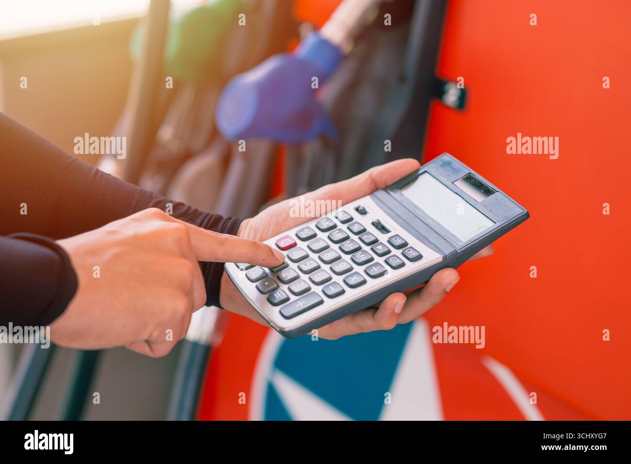 Primo piano stazione di servizio personale calcolatrice manuale calcolo del prezzo del carburante per auto costo basso o alto costo bolletta, attività petrolifera Foto Stock