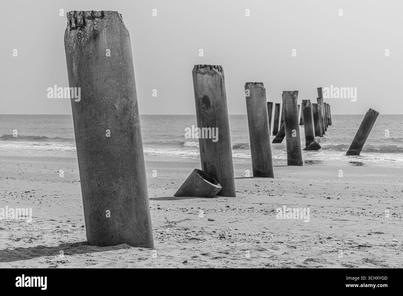 vecchio palo in cemento abbandonato sulla spiaggia, fotografia d'arte in bianco e nero Foto Stock