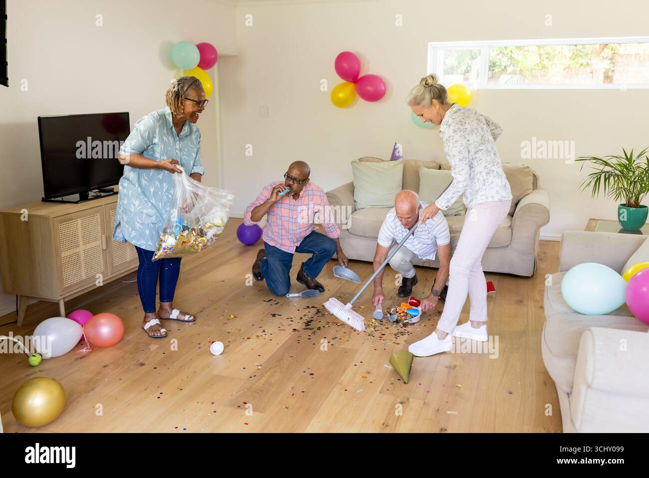 Ripulisce le decorazioni delle feste, amici anziani che lavorano insieme in salotto Foto Stock