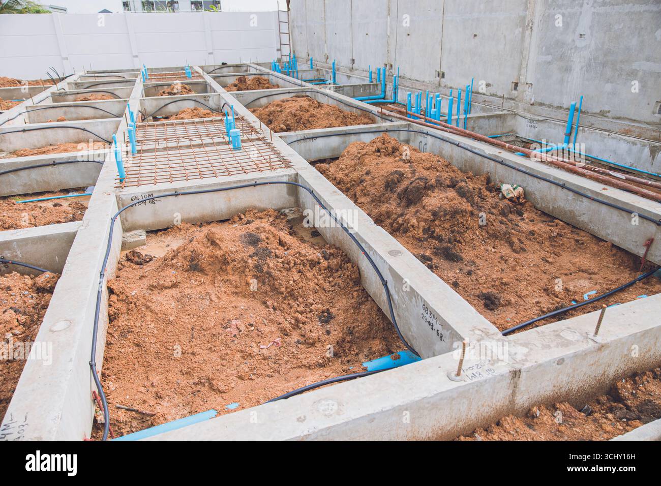 Costruzione di fondazioni, fondazioni poco profonde pavimentazione piano terra travi in calcestruzzo e strutture di tubi Foto Stock