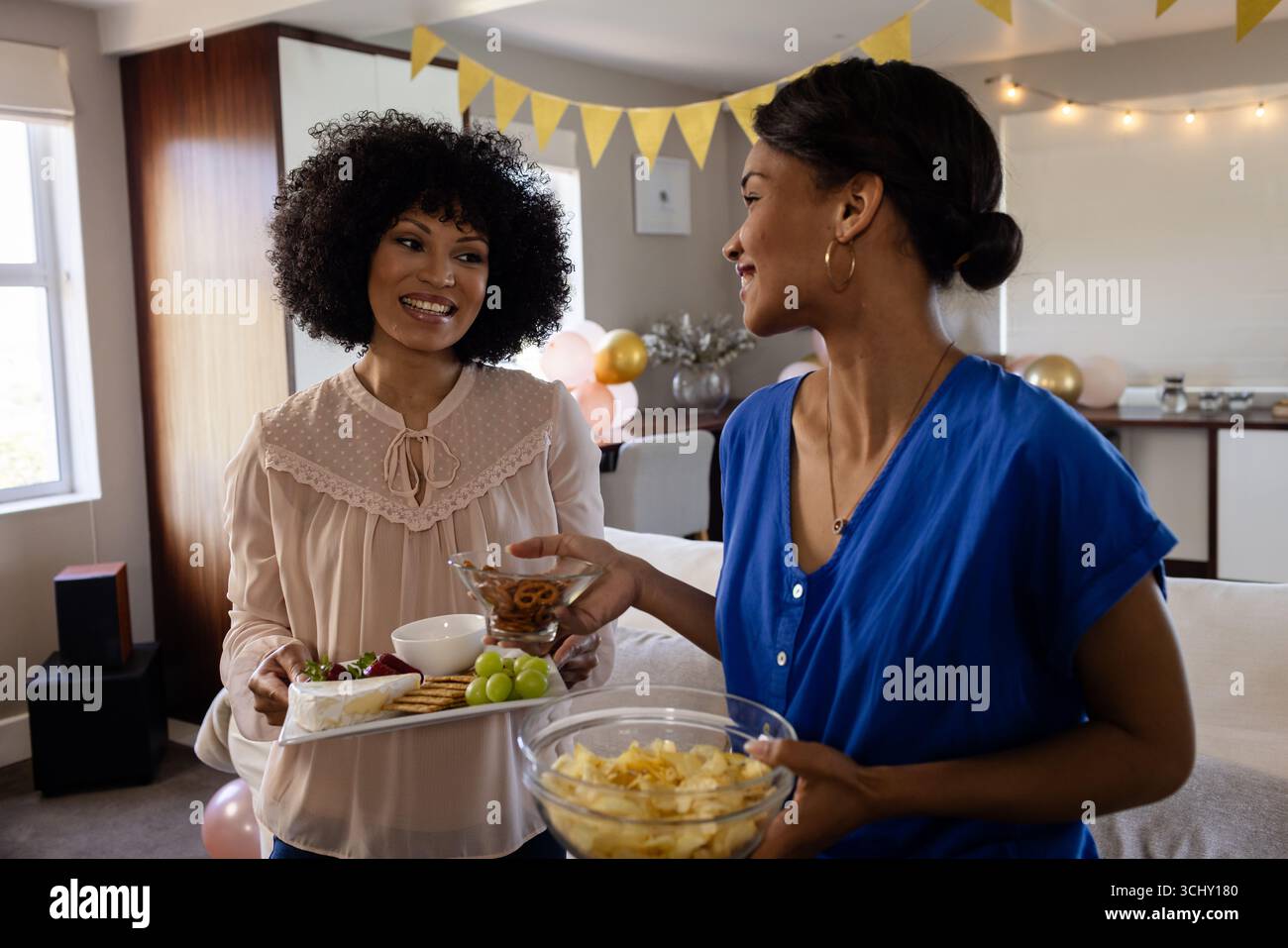 diverse amiche si godono spuntini e chiacchierate a casa Foto Stock