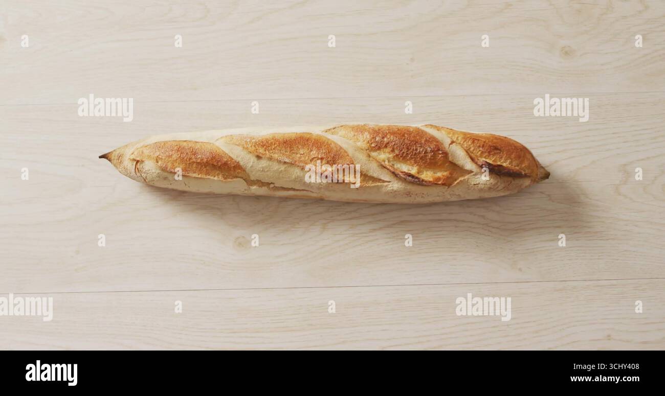 Baguette in stile francese che mostra croste su un ripiano in legno chiaro, mostrando l'arte della pasticceria Foto Stock