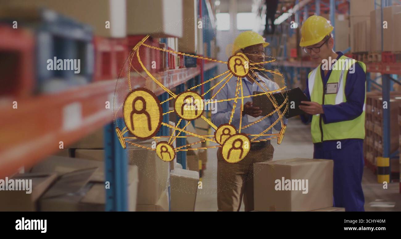 Gli addetti al magazzino indossano cappelli di protezione, giubbotti di controllo su tablet nei corridoi del magazzino, con mascherina Foto Stock