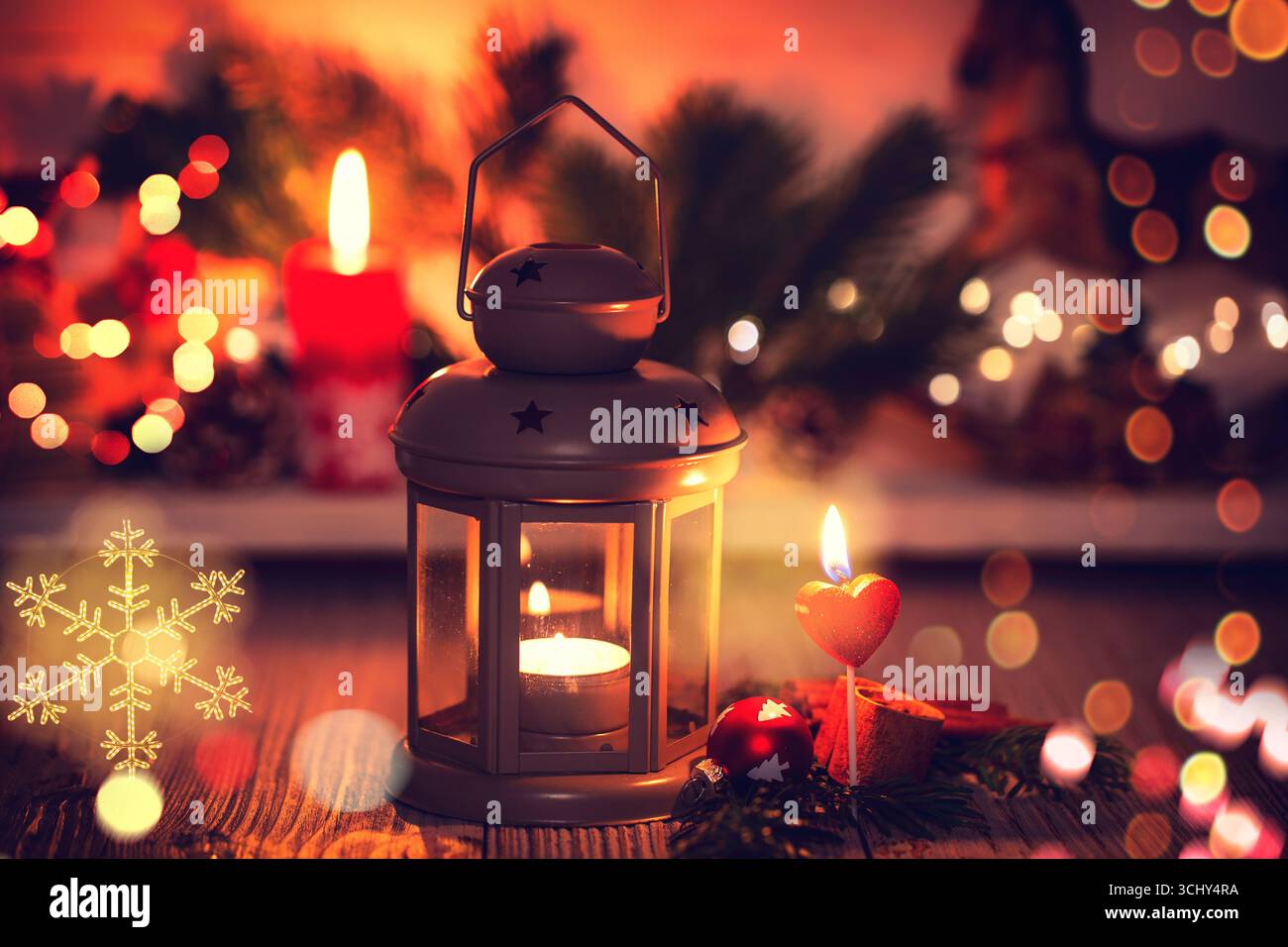 Lanterna con la luce del tè davanti alle decorazioni natalizie, in composizione Foto Stock